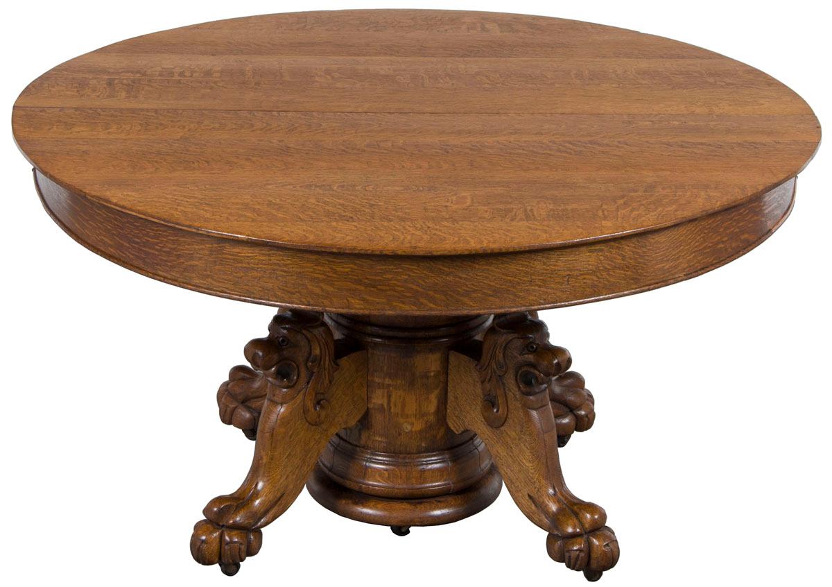 This fantastic oval (almost round) carved oak lion head table is a late Victorian era antique from England. It was made sometime around the years 1890-1900. And while it no longer retains any leaves, the function to expand the table is still there.