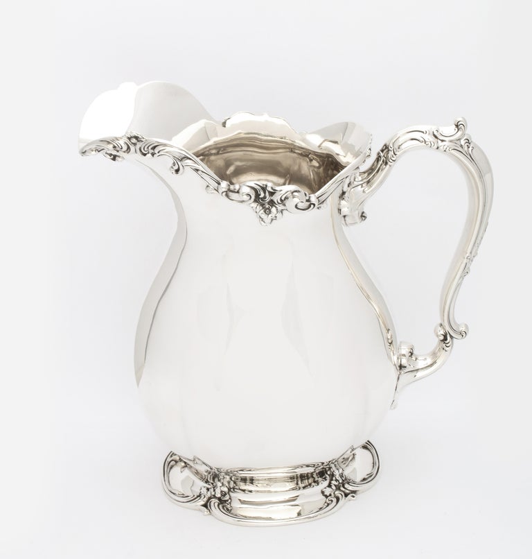 Large, Victorian Period, sterling silver water pitcher (possibly Old Chantilly) on pedestal base, Gorham Manufacturing Corp., Providence, Rhode Island, year-hallmarked for 1903. Measures 9 1/4 inches high (at highest point) x 9 inches wide (from