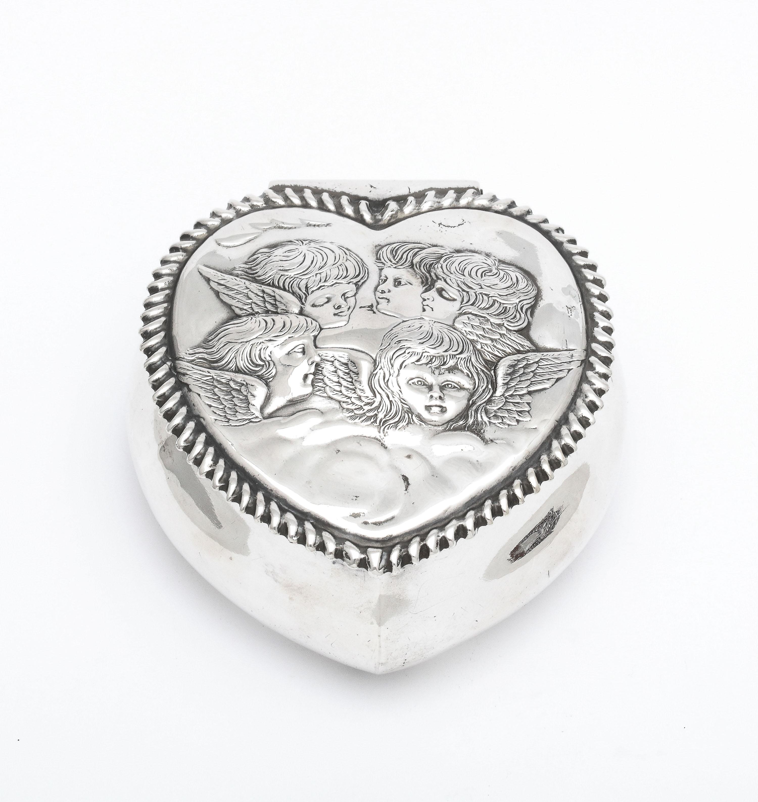 Victorian, sterling silver heart-form trinkets box with hinged lid and gilt interior, Birmingham, England, year-hallmarked for 1897, H. Matthews - Maker. Lid is designed with a Joshua Reynolds motif - The Cherubs in the Clouds. Border of lid is