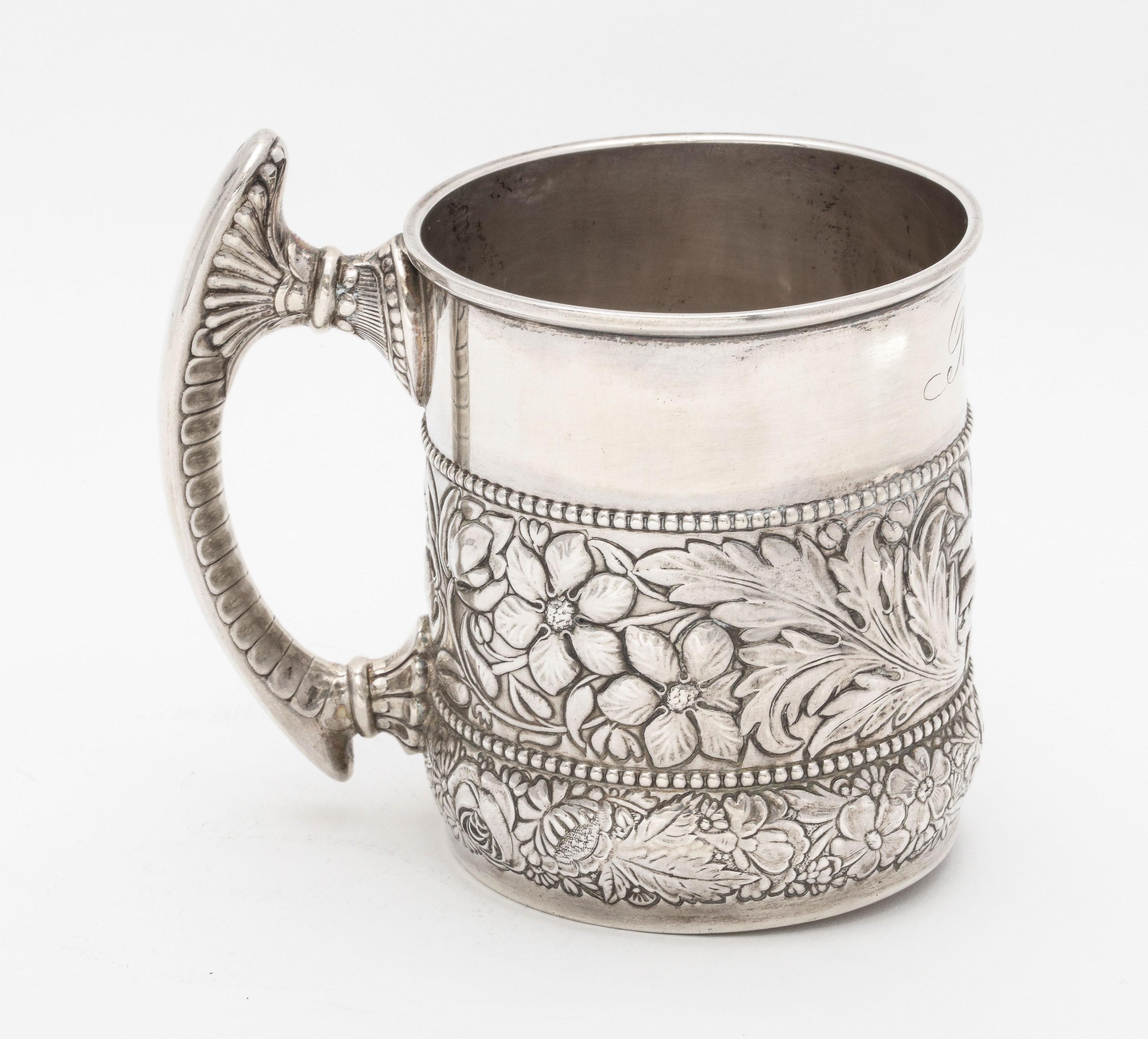 Victorian Period, sterling silver mug/cup, Gorham Mfg. Co, Providence, Rhode Island, year hallmarked for 1890. Decorated with leaves and flowers. Handle fans out in design. Measures 3 3/4 inches high (to top of handle) x 4 inches wide from edge of