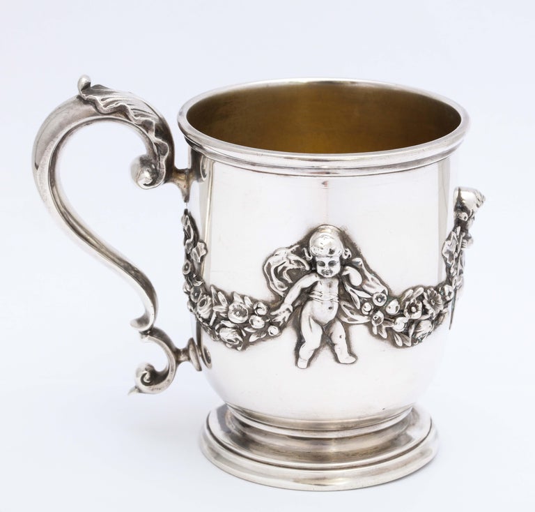 Victorian period, sterling silver mug/cup on pedestal base, New York, Ca. 1895, Black, Starr and Frost - makers. Mug is decorated with garlands and cherubs. Interior is lightly gilded. Measures 4 inches high to top of handle x 3 inches high to edge