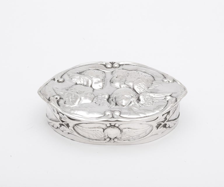 Victorian, sterling silver trinkets box with hinged lid and gilded interior, decorated with the Joshua Reynolds' motif of The Cherubs in the Clouds, London, year-hallmarked for 1899, William Comyns - maker. Measures 3 inches wide (at widest point) x
