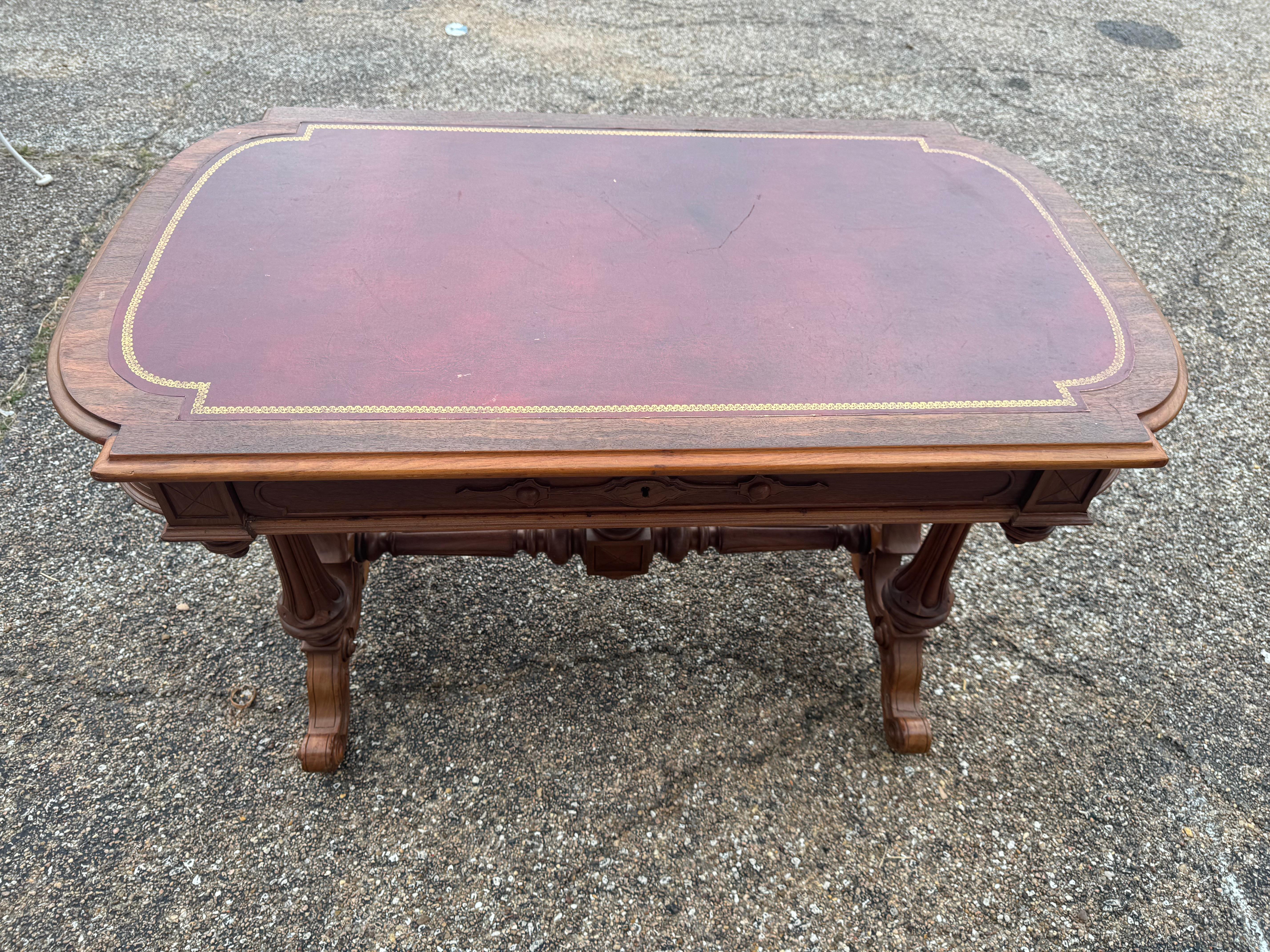 Il s'agit d'un beau bureau d'époque victorienne. 
Il est fabriqué en noyer et possède des pieds cannelés.
Le brancard est doté d'un fleuron en forme de toupie.
Les pieds sont enroulés vers l'arrière et la pièce 
est joliment sculptée. La partie