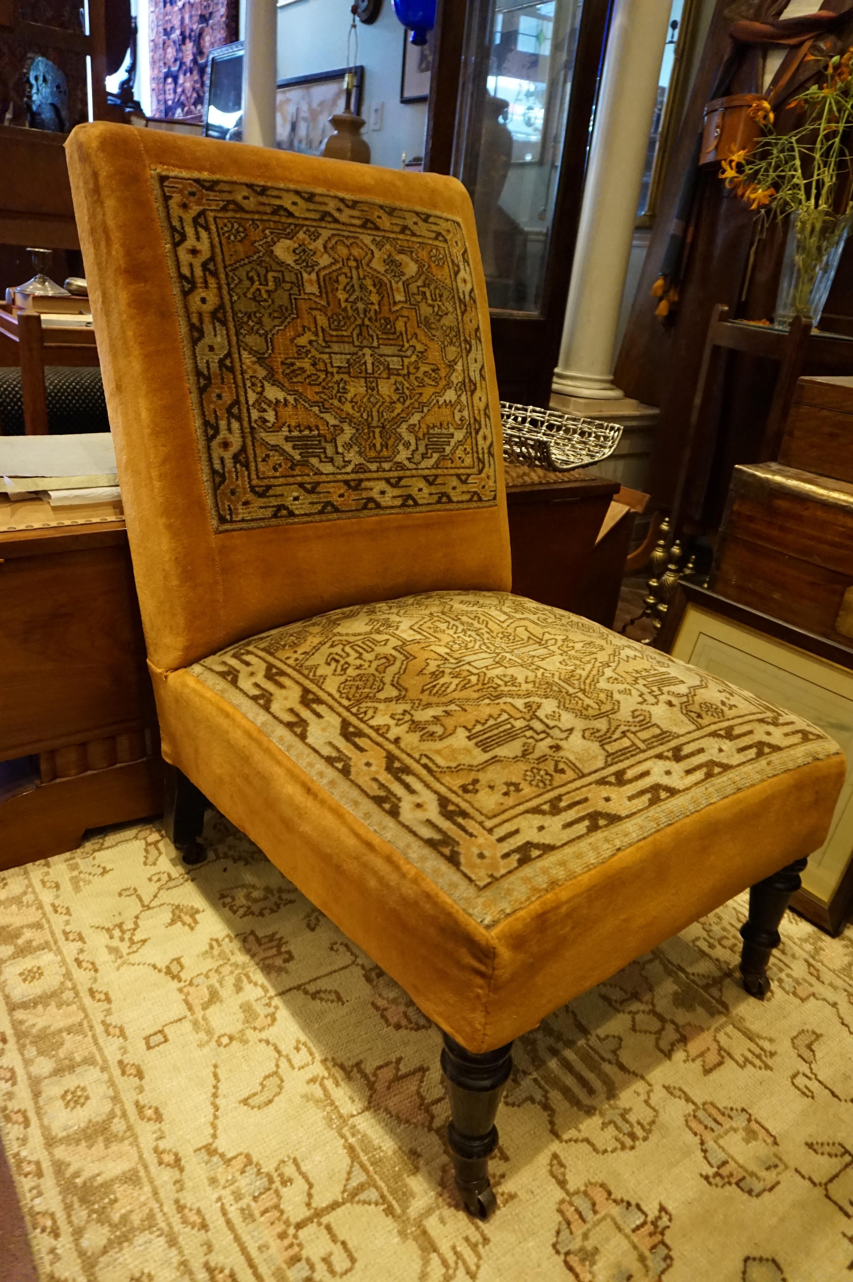 Antique low chair with hand knotted tribal carpet upholstery in saffron hues, circa 1890. Original horsehair stuffing which is still comfortable. On casters. Ideal fire side or slipper chair with originality, warmth and character.

      
