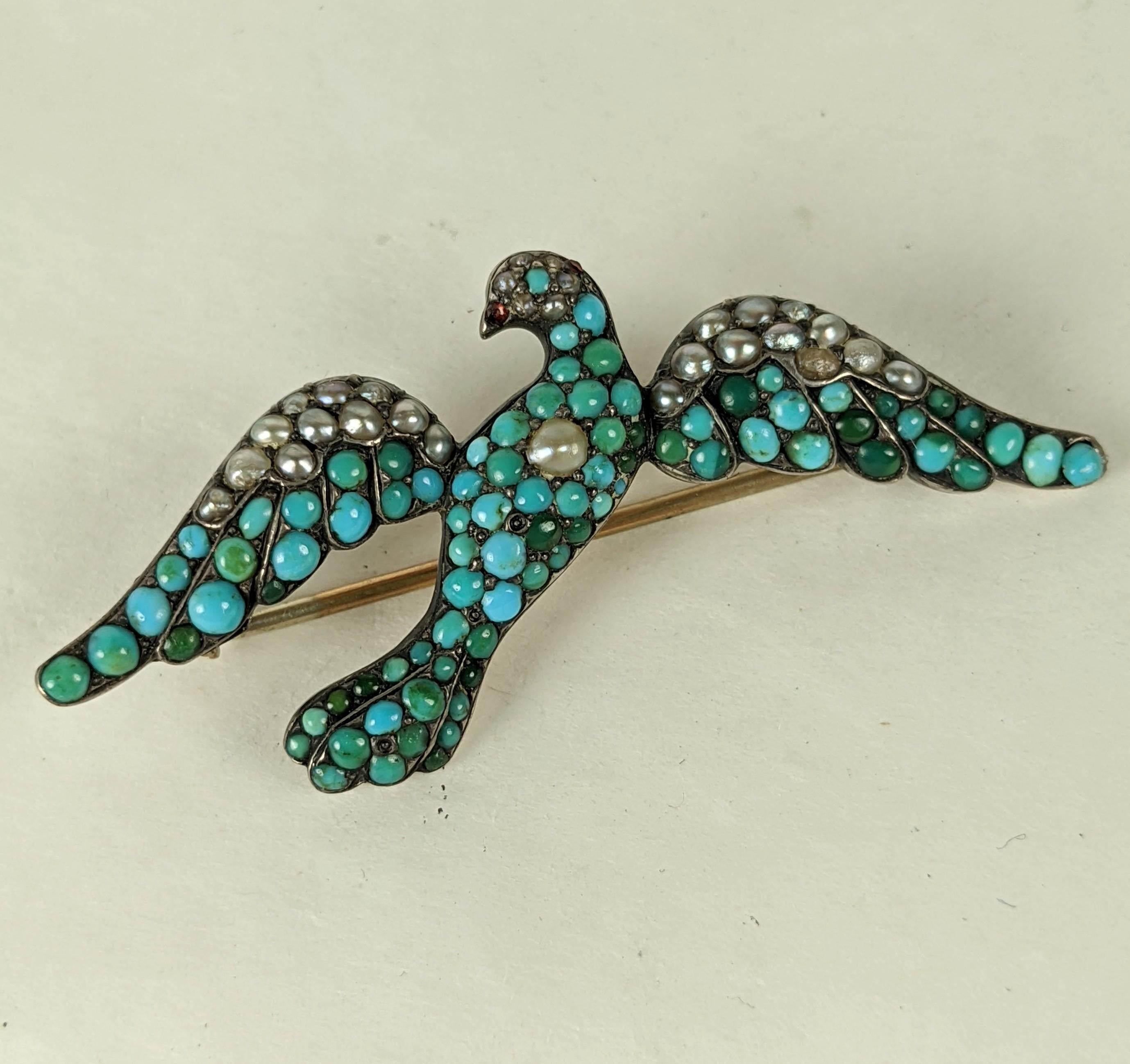 Victorian Persian Turquoise and Seed Pearl Dove from the late 19th Century. Pave turquoises and pearls are used to decorate the dove in flight with tiny garnet beak. 
Set in gilt silver. Almost 2