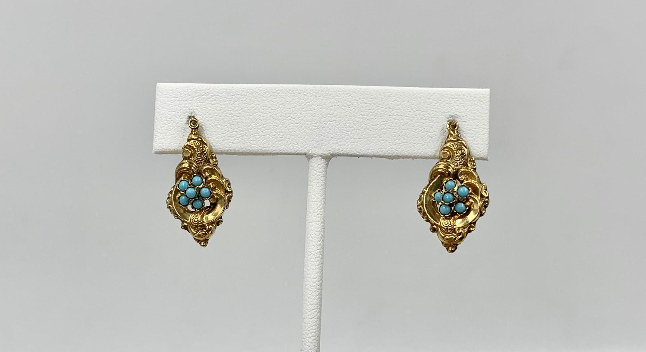 A rare pair of Persian Turquoise Victorian Flower Motif Dangle Drop Earrings in 10 Karat Gold.  The exquisite earrings have a Forget Me Not flower in the center with Persian Turquoise cabochons.  The color of the Turquoise is absolutely wonderful. 