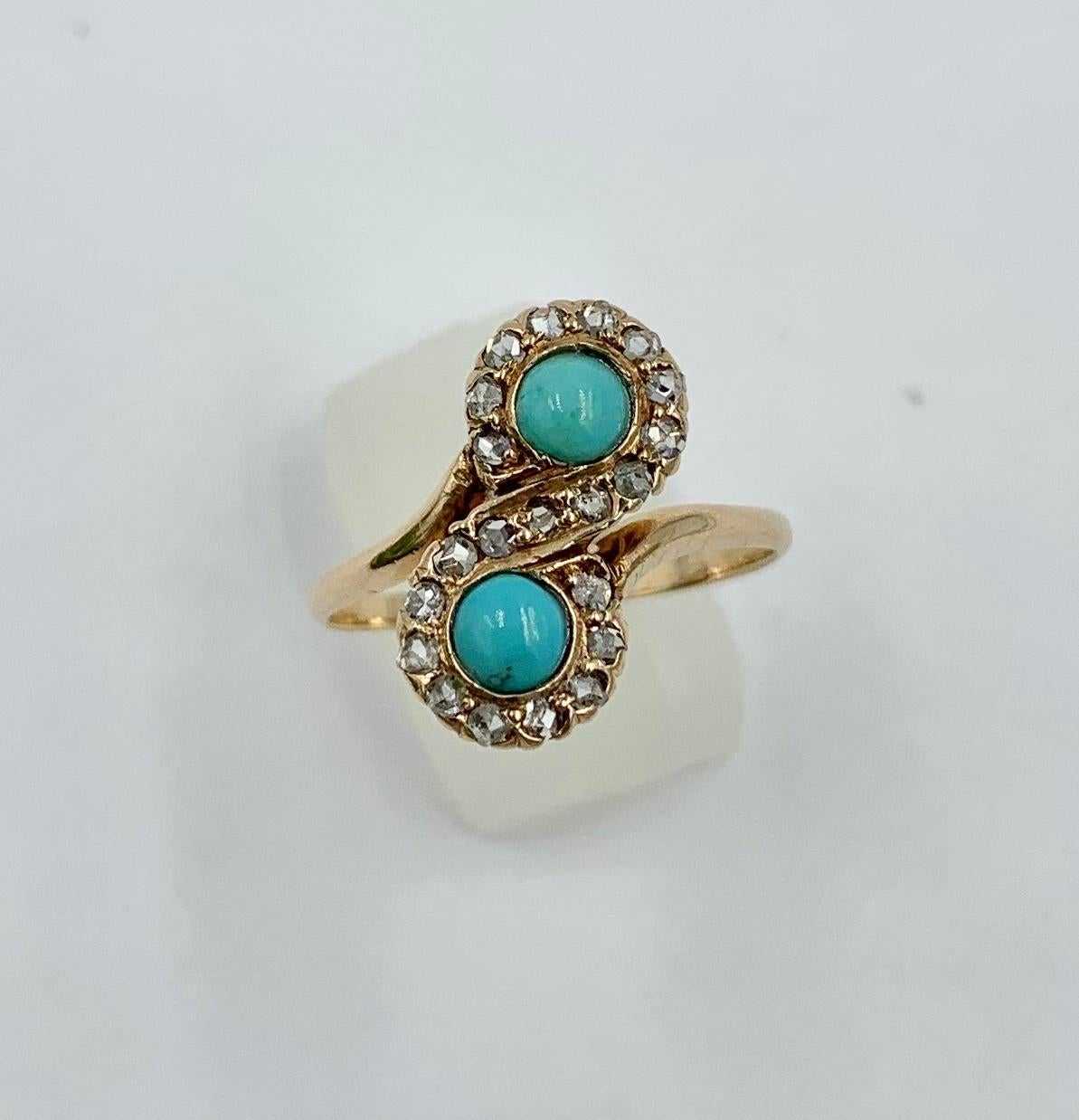 An Antique Victorian - Edwardian Ring with two gorgeous natural Persian Turquoise cabochons of stunning beauty. The Turquoise gems are surrounded by a twisting halo of 21 sparkling antique Rose Cut Diamonds. This design is often referred to as Toi