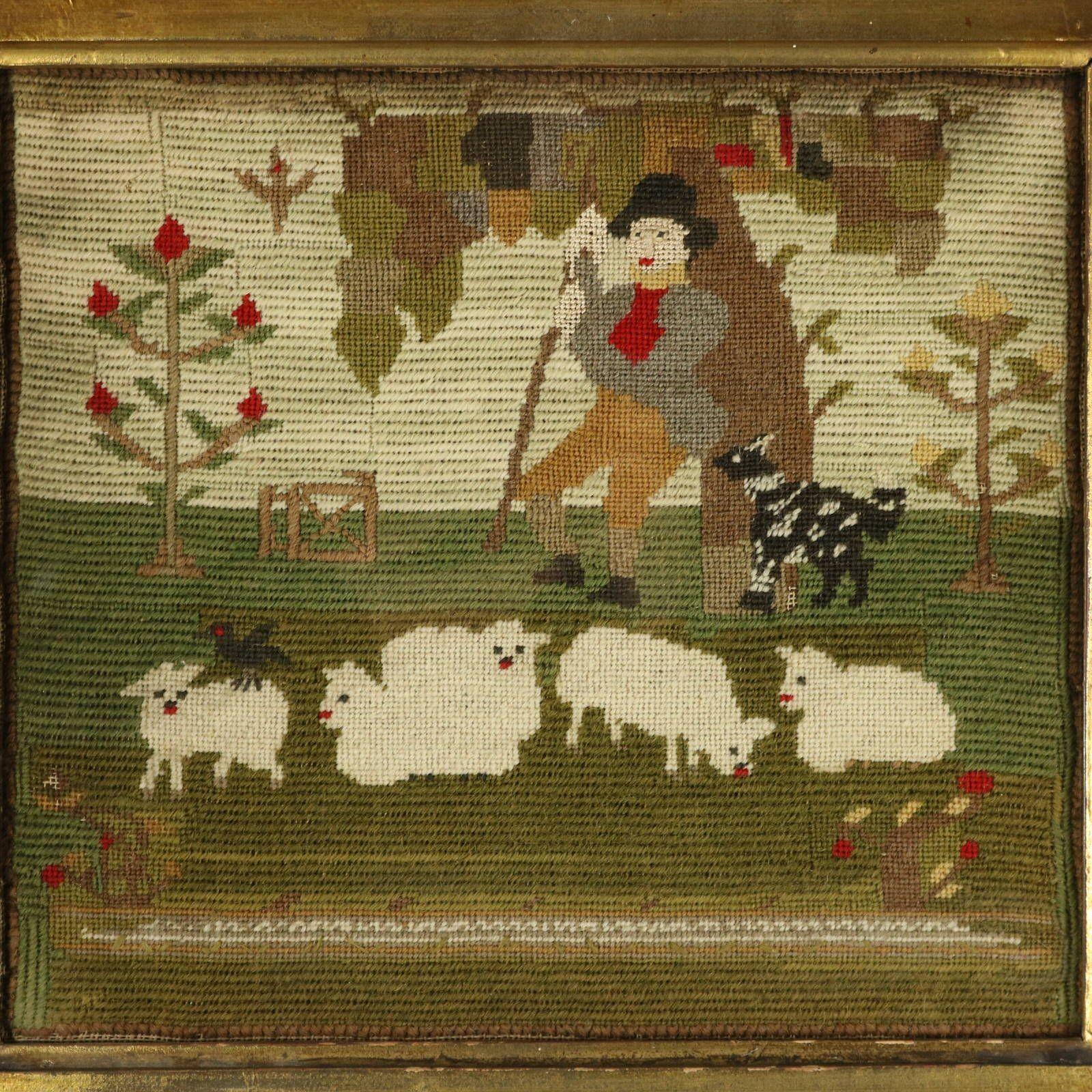Broderie victorienne au petit point représentant un berger avec son troupeau de moutons. Il s'adosse à un arbre, son chien à ses côtés. Un mouton a un corbeau sur le dos. La pièce est travaillée au petit point, avec de la laine sur un fond de toile.