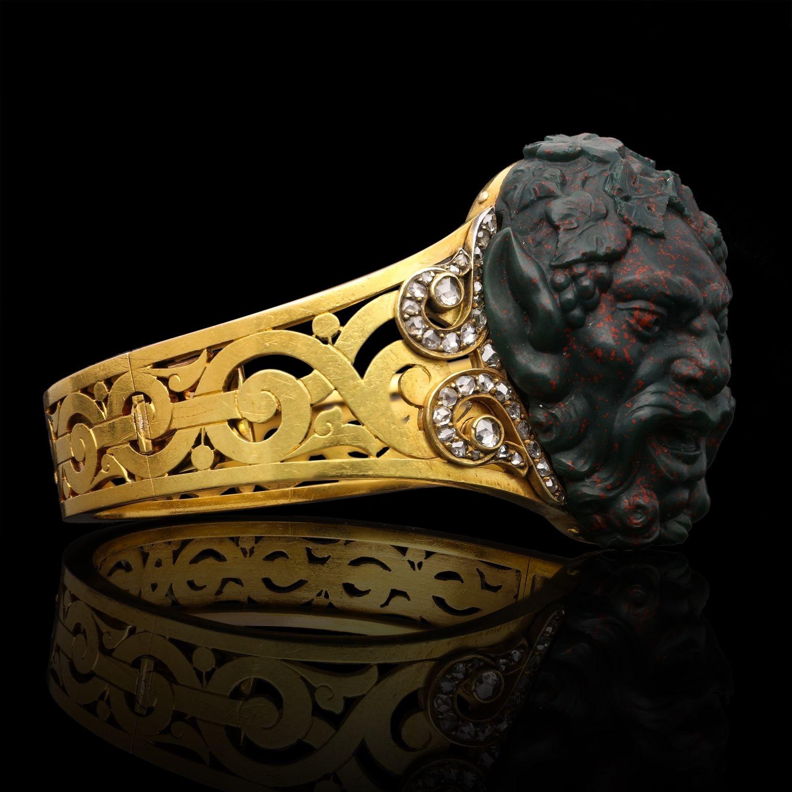 A magnificent Victorian gold and hardstone bracelet circa 1880, set to the centre with a beautifully carved piece of bloodstone by the 19th century sculptor and gem engraver Henri Burdy in the form of the head of Bacchus the Roman god of wine,