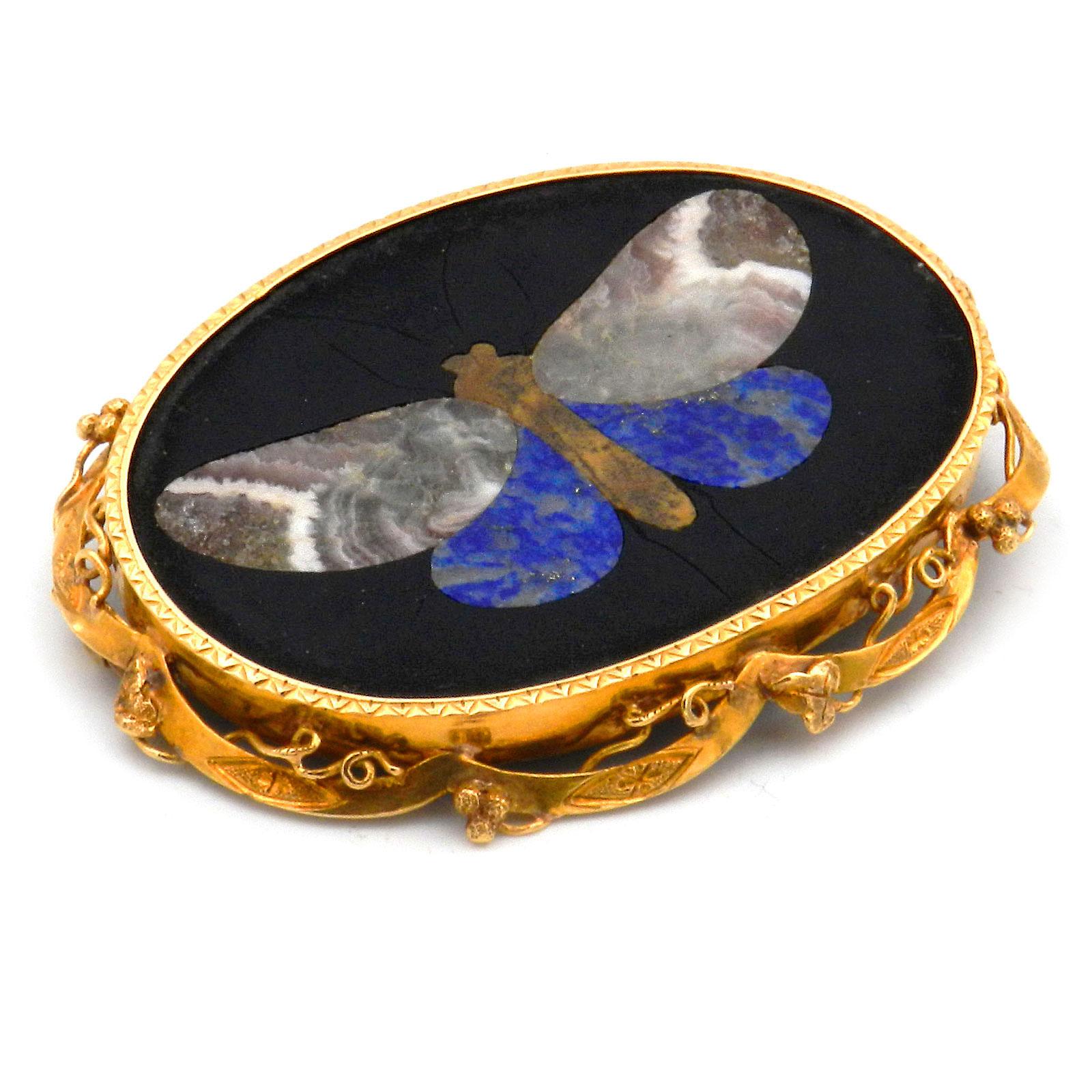 Victorian Pietra Dura Butterfly 18K Gold Brooch circa 1870

Large Pietra Dura brooch in a filigree gold frame made of ivy tendrils. The fine inlaid work shows a magnificent butterfly made of different colored gemstones. It stands out against the