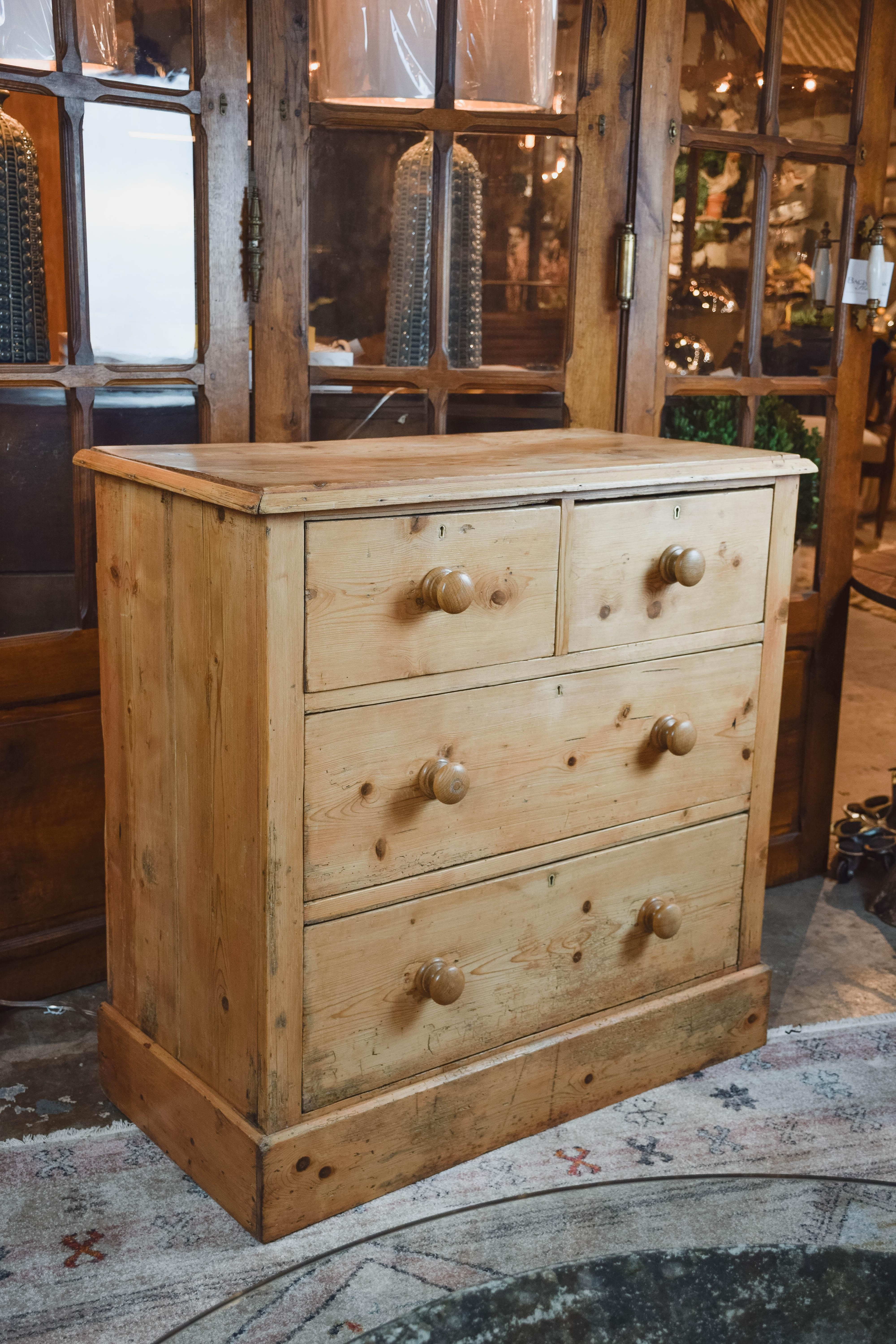 Found in the English countryside, this Victorian pine chest from England has a beveled edge around the top, a two-drawer over two-drawer configuration, wood knobs and an apron around the bottom.