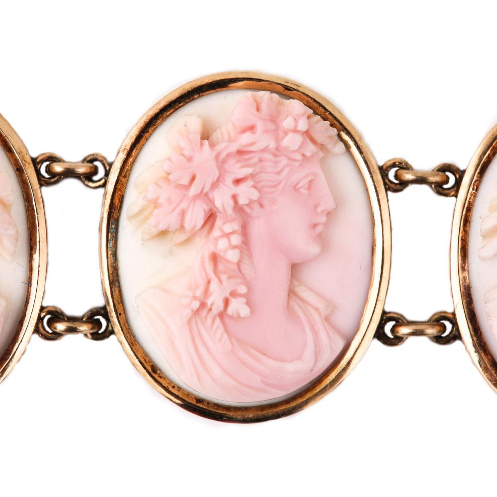 A rare Russian victorian 14 karat yellow gold pink & white conch shell cameo bracelet with 7 ornately carved oval panels, each with a female bust depicted in a Greco-Roman style with lots of floral elements masterfully carved into their coiffures or