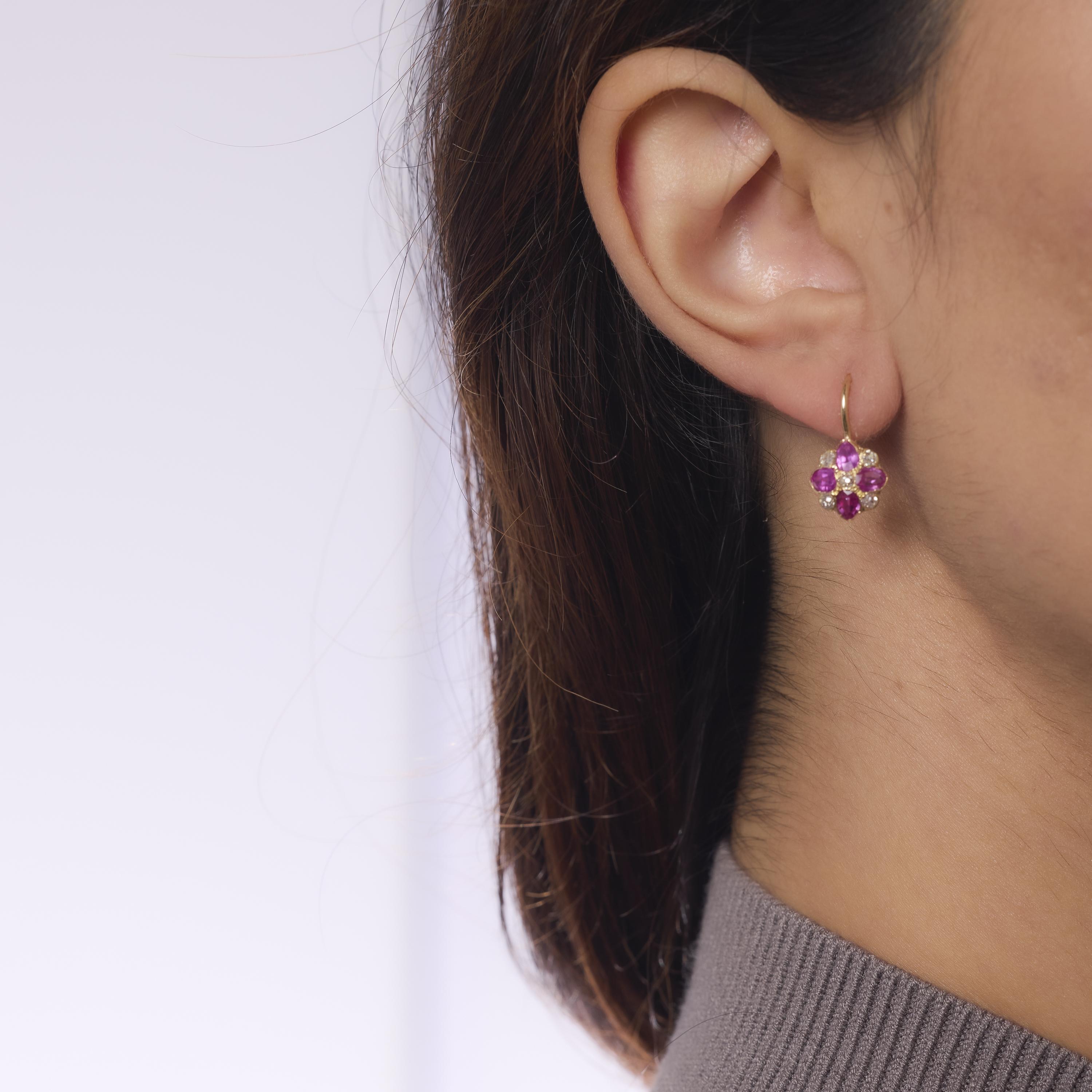 These Victorian 18k yellow gold earrings dazzle with eight vibrant pear shape pink sapphires framed by ten glittering old mine cut diamonds. Crafted in the early 1900s, their romantic silhouette and antique sparkle evoke the elegance and charm of a
