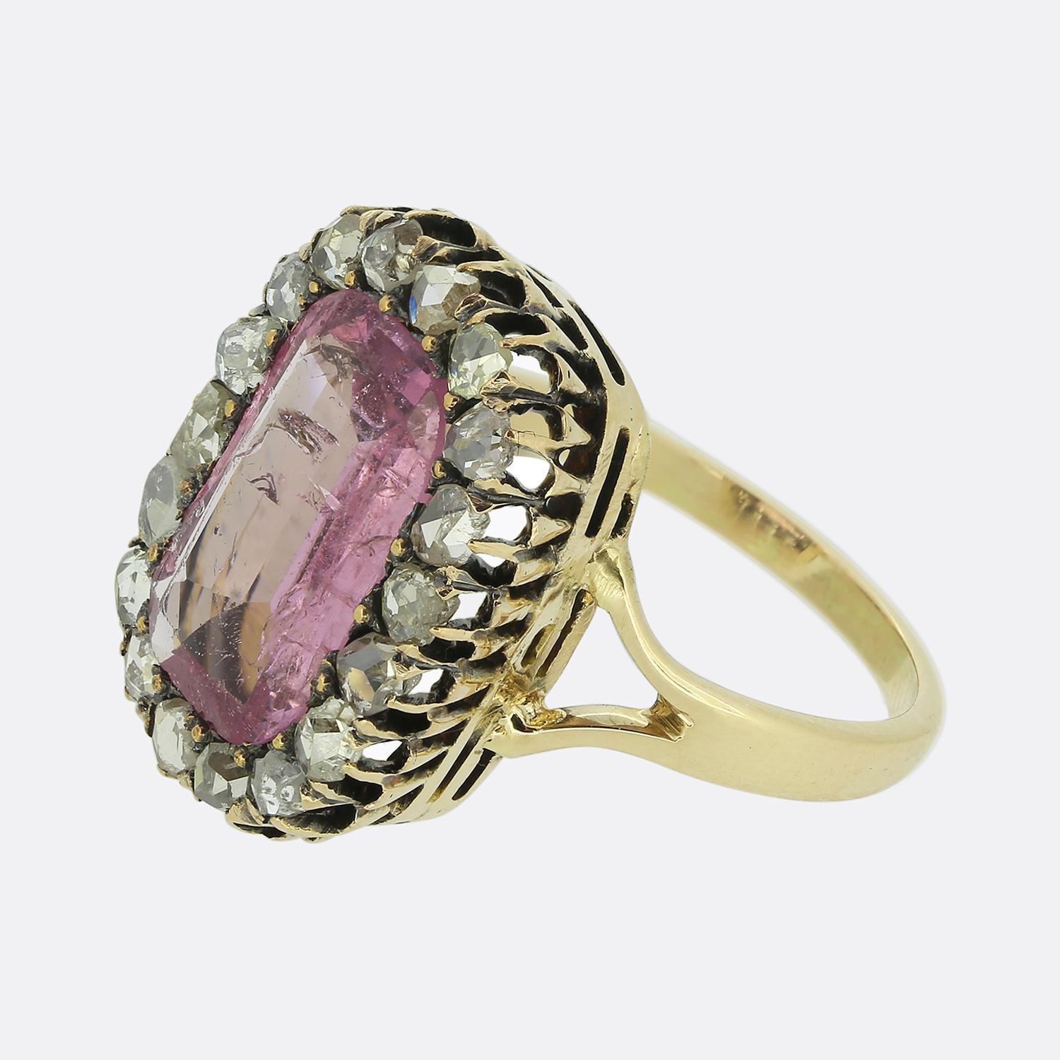 Here we have a delightful dress ring showcasing a captivating pink spinel at the centre of the face, drawing the eye with its soft, alluring hue. Surrounding this bold principal stone is a frame of shimmering rose-cut diamonds; all of which are set