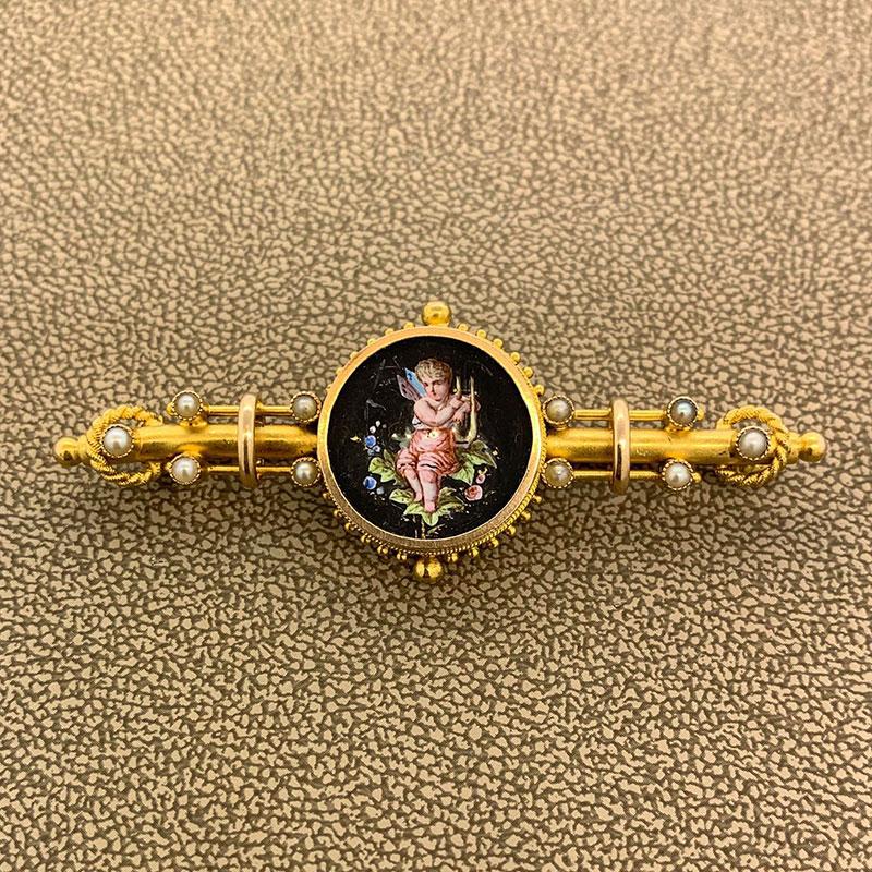 An original antique from the 19th century, this 14k brooch is studded with seed pearls and centers a porcelain painting of a child of the forest playing his harp.

 Length: 2.5 inches
