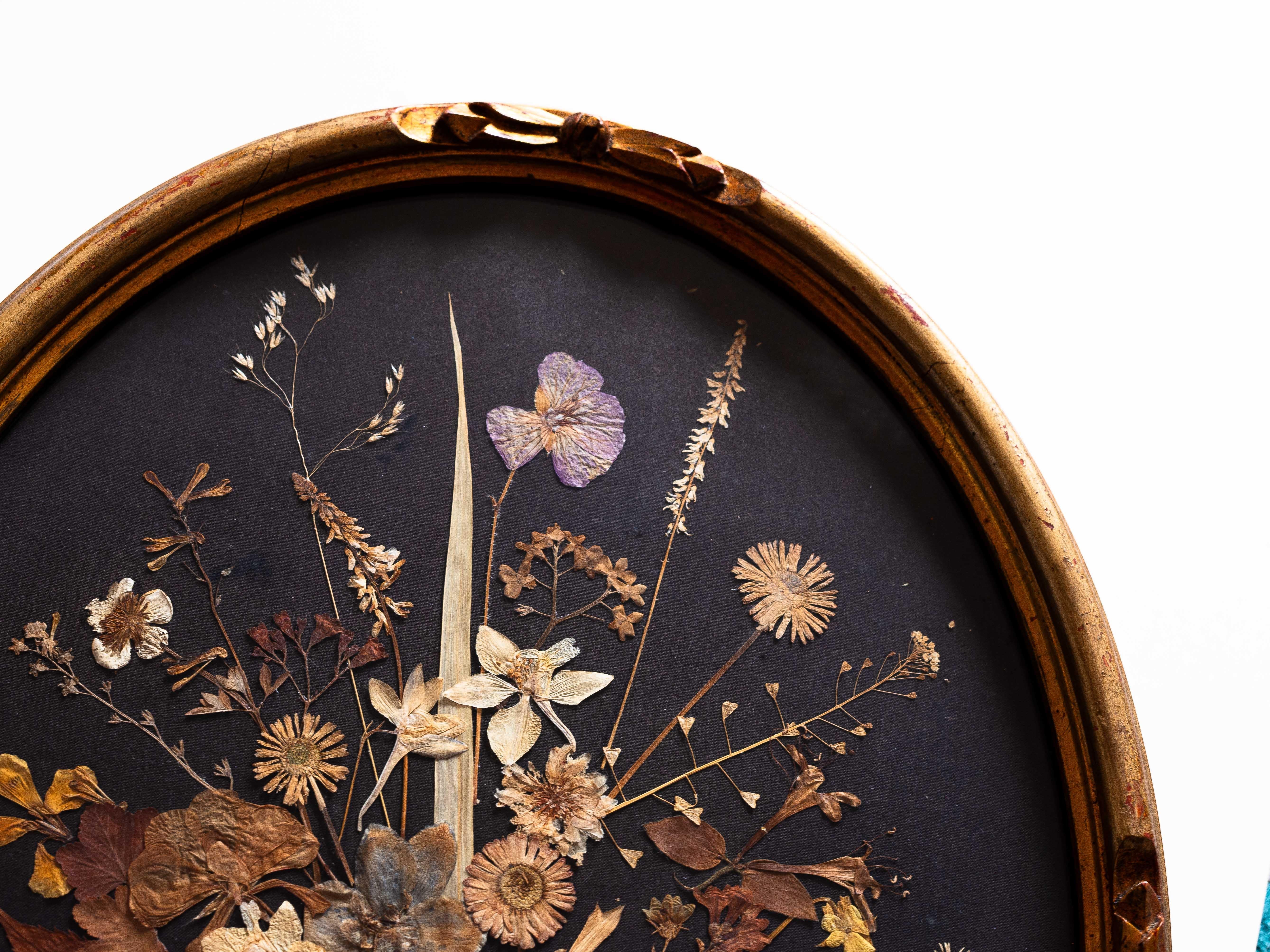 Victorian Pressed Flower Oddity, Botanical Art in Gilt Oval Frame, 19th Century

Antique botanical composition featuring a delicate array of hand-pressed flowers and foliage, artfully arranged against a dark fabric background. 

Housed in an oval