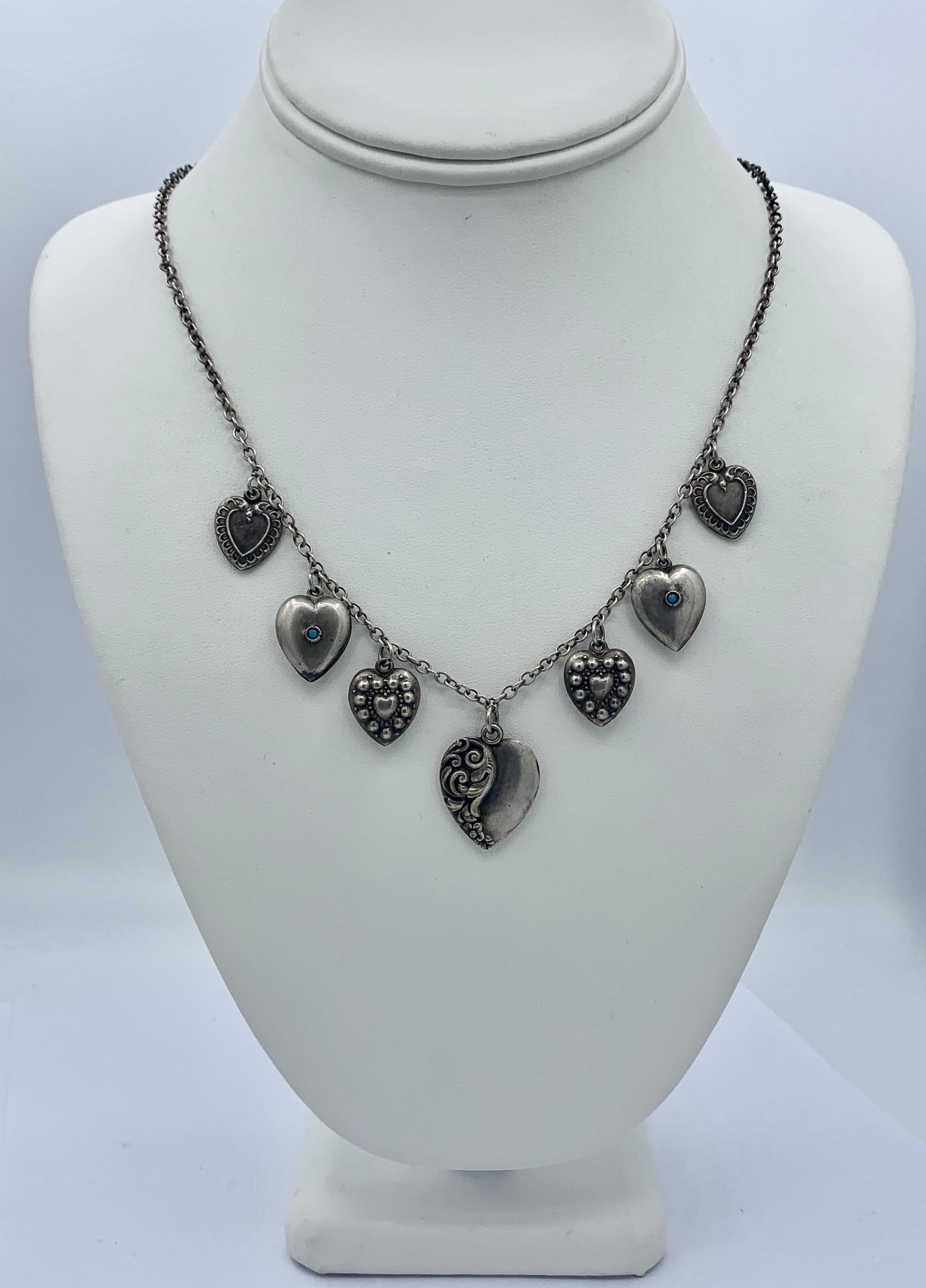 This is a beautiful Antique Victorian - Art Deco Puffy Heart Pendant or Charm Necklace in Sterling Silver with Turquoise adornments.   The seven heart charms are beautifully made and each one is signed Sterling.  Two are adorned with Turquoise