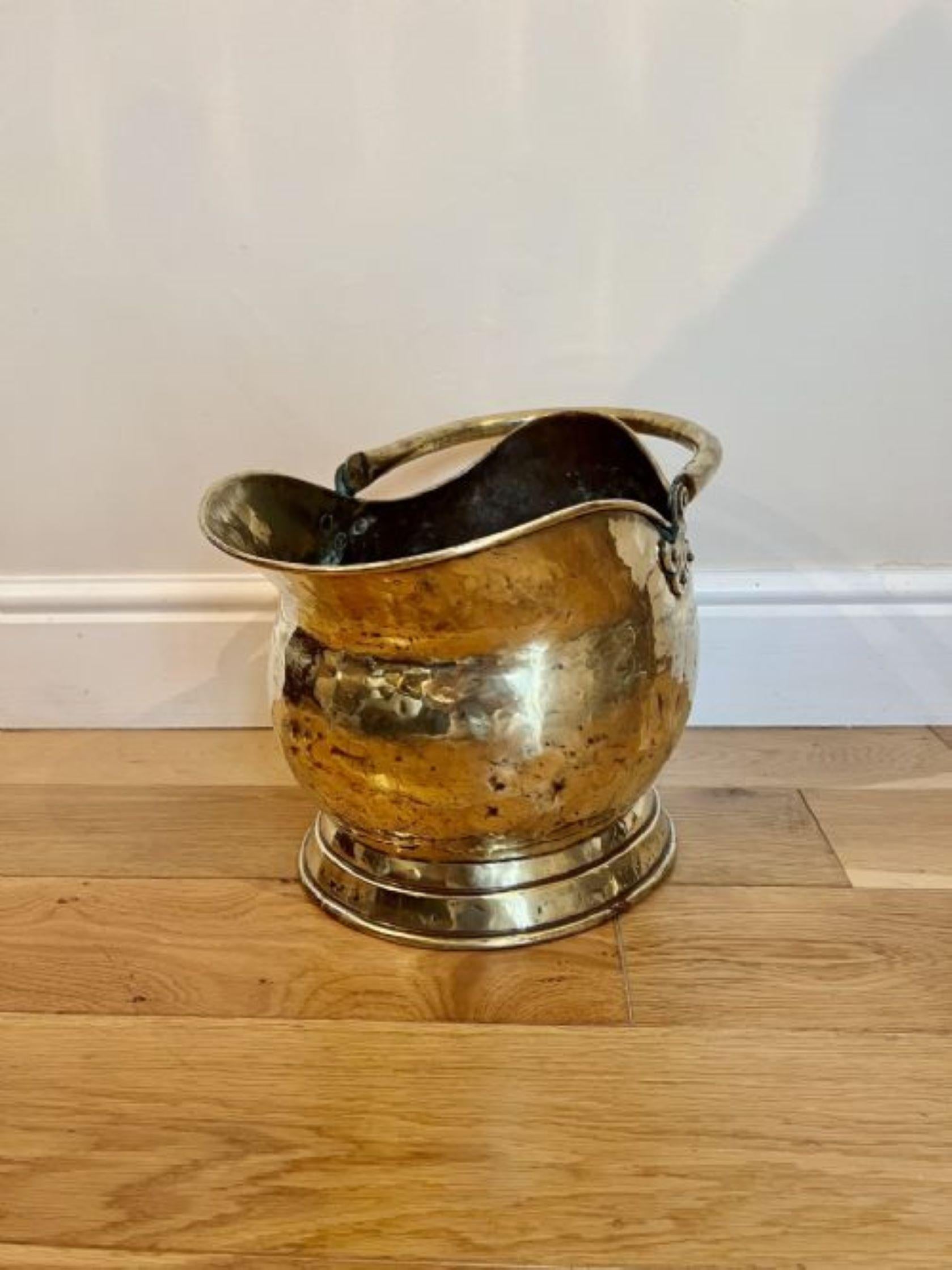 Antique Victorian quality brass helmet coal scuttle having a shaped carrying handle with a shaped quality brass helmet coal scuttle 
