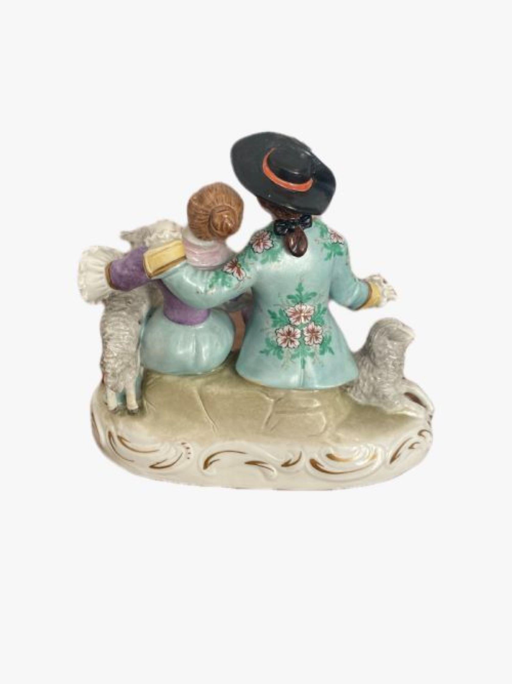 Late 19th Century English Victorian antique porcelain Continental Group having two figures sitting on a shaped base with gilded scroll decoration in colourful period clothing holding two sheep in wonderful hand painted purple, blue, white, black and