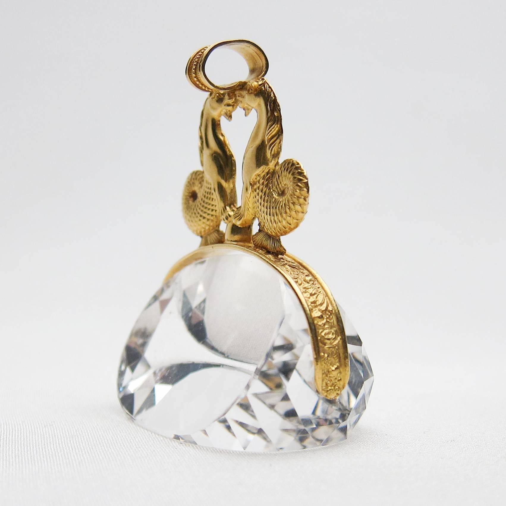 This spectacular crystal fob is a paragon of antique beauty! The crystal-clear quartz stone is topped with two (joined) 18KT gold seahorses. The oval, triangular-faceted colorless stone measures 38mm x 23mm x 23mm. This fob would make a stunning
