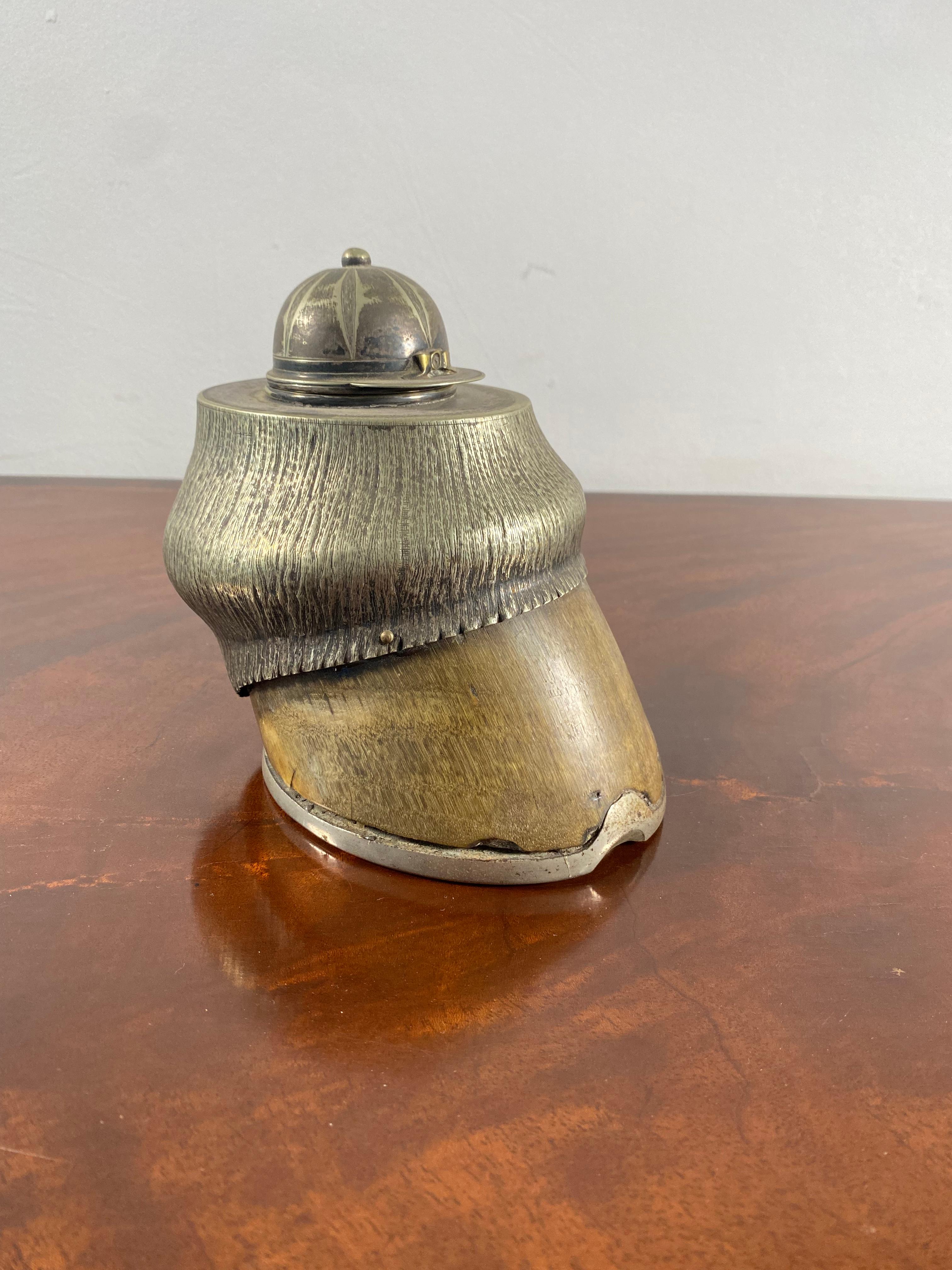 A very fine racehorse taxidermy hoof modelled as an inkwell, the inkwell lid depicting a jockey's cap. Late 19th century.