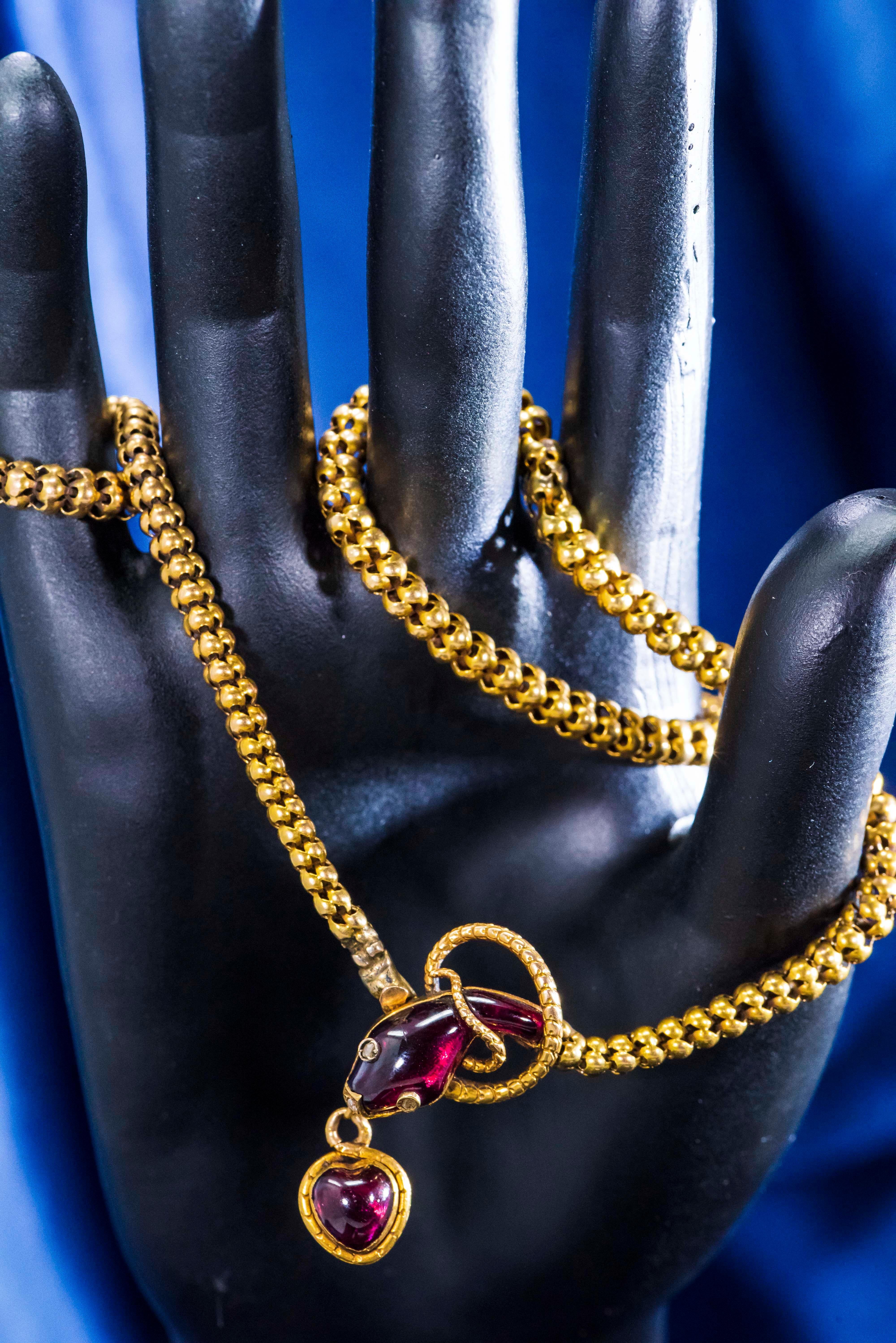 Dimensions
The Circumference, when the clasp is closed: 42.5cm.

Additional Details

The present necklace is a sophisticated Victorian era gold necklace circa 1850-1880, designed as a finely carved almandine garnet snake head holding an almandine