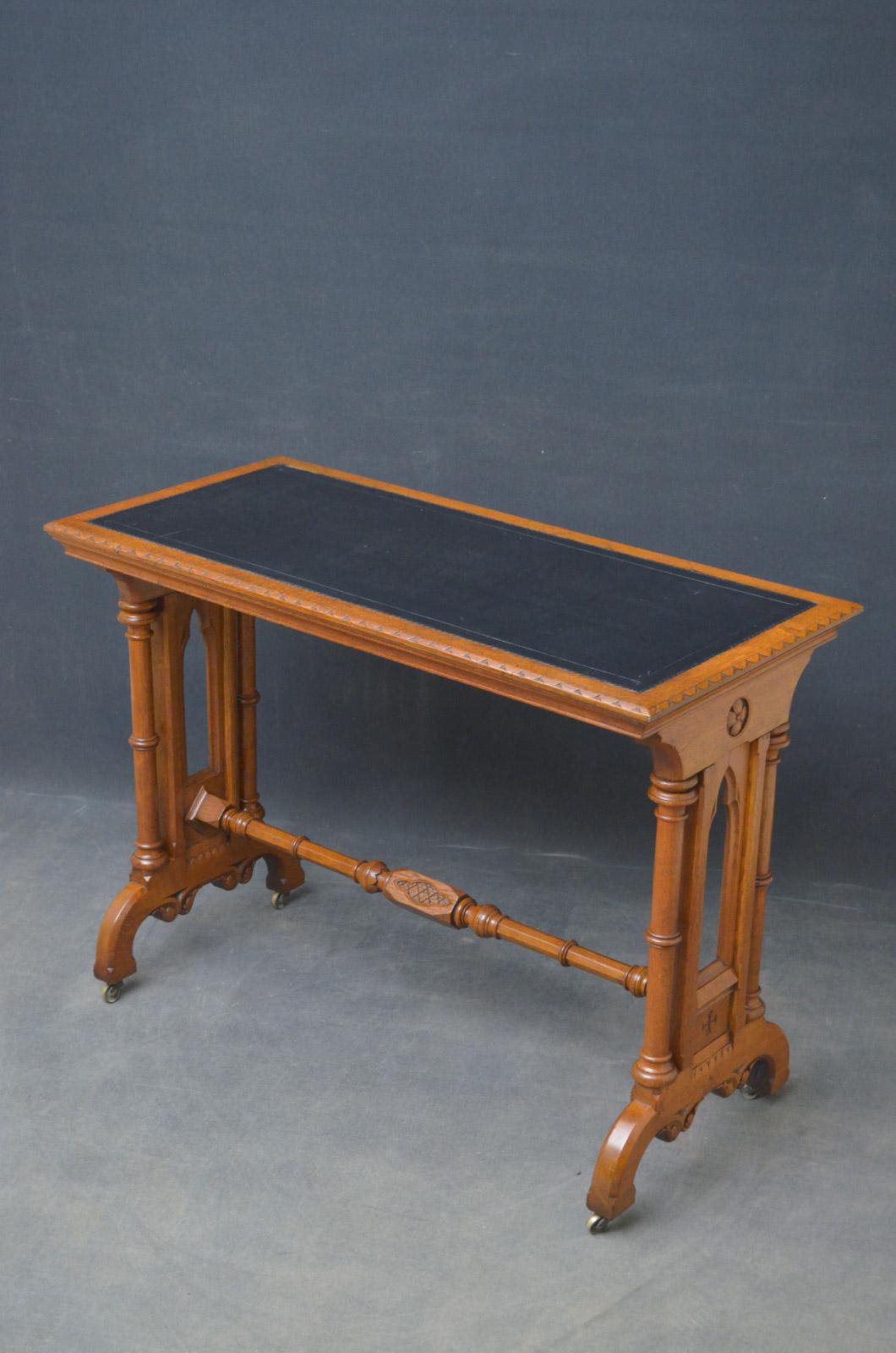 Sn4626 stylish Victorian writing table in oak, having black leather writing surface and do tooth carved edge, raised on carved and pierced supports with flanked by turned columns terminating in downsept legs and brass castors. This antique library