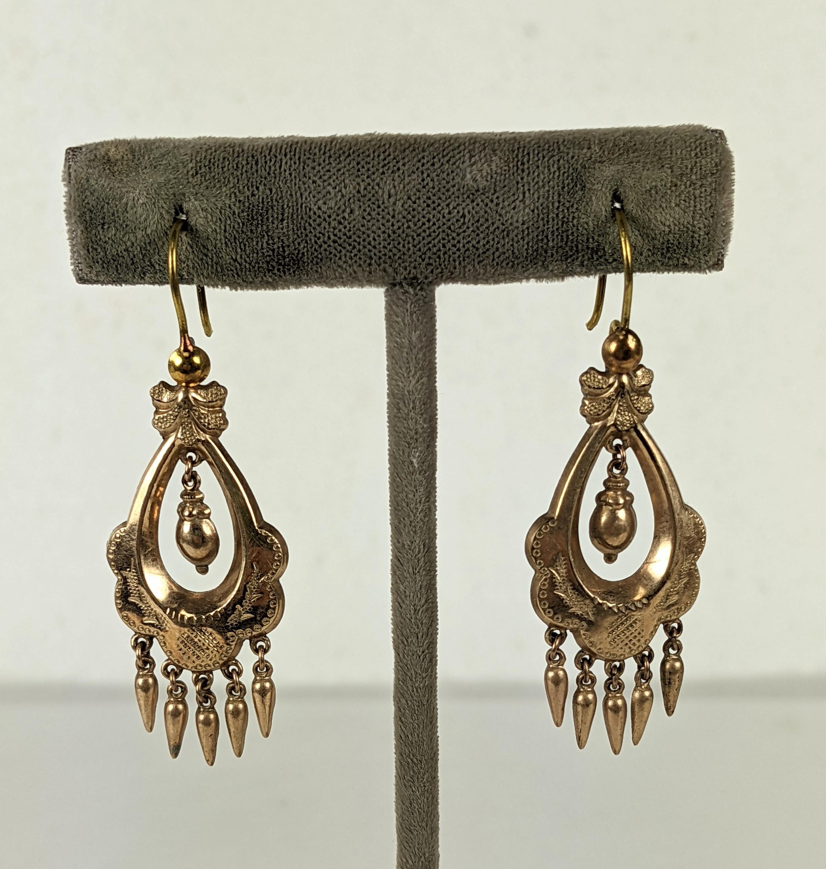 Victorian gold filled articulated long earrings in the Renaissance Revival taste. Gold filled metal has incised foliate motifs with two center hanging urns with small pendant drop fringes and french wire hooks. Excellent Condition. 1880's. 
L 1.3/4