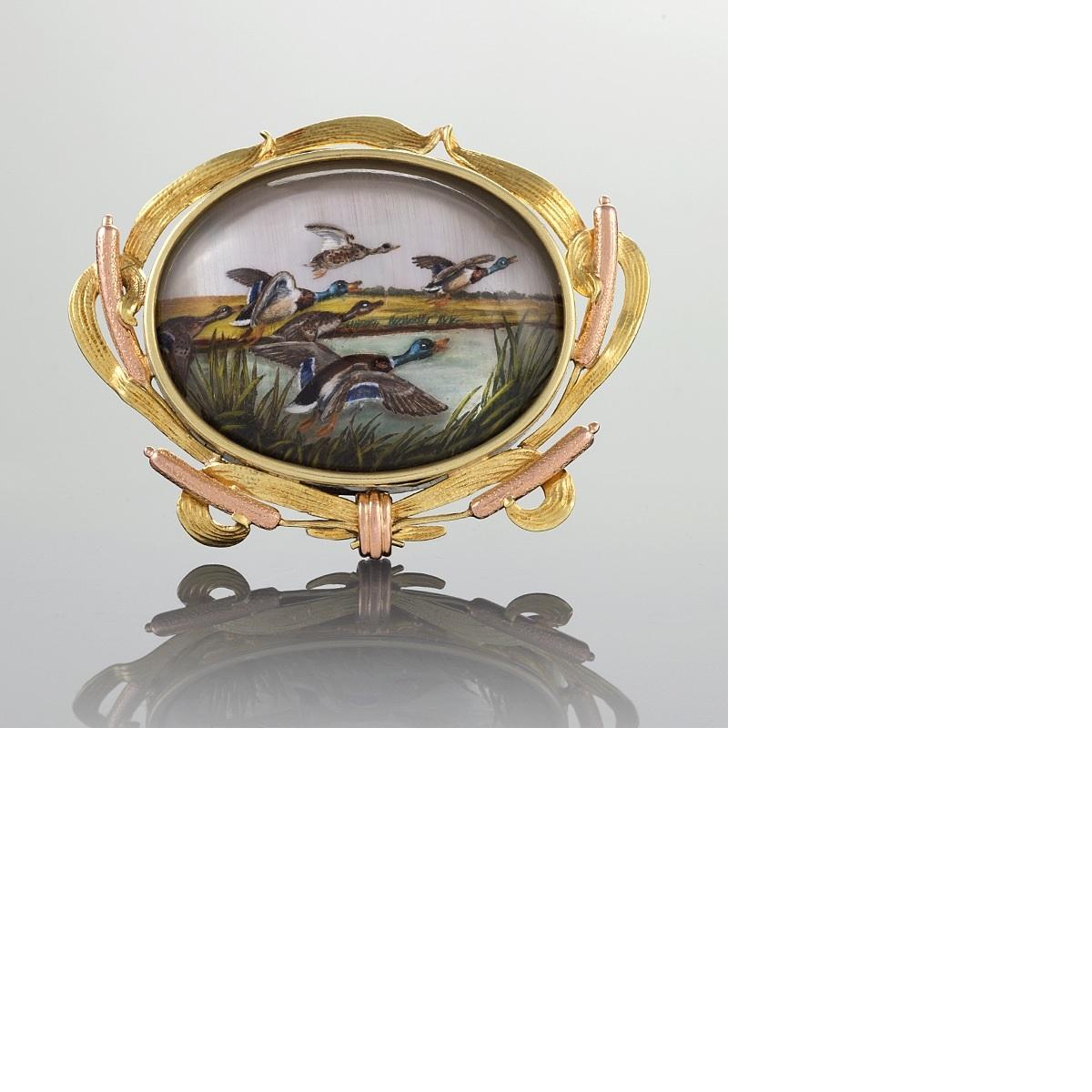An English Victorian 18 karat gold reverse crystal brooch. The finely painted crystal brooch represents ducks in lift-off.  The yellow and red gold frame is decorated with dimensional pussy willows intertwined with ribbon.  Circa 1880's.

Reverse