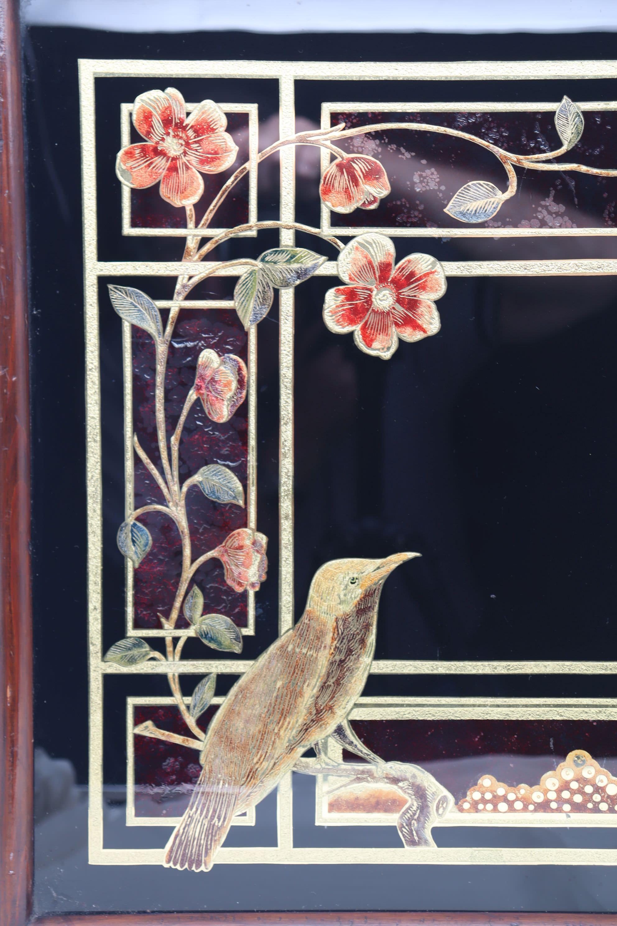 This large Victorian reverse painted glass tray is decorated with a scene of birds, flowers and a butterfly all above a gilded grid on a black ground. The glass has been etched and engraved on the back, then painted and gilded and mounted in a