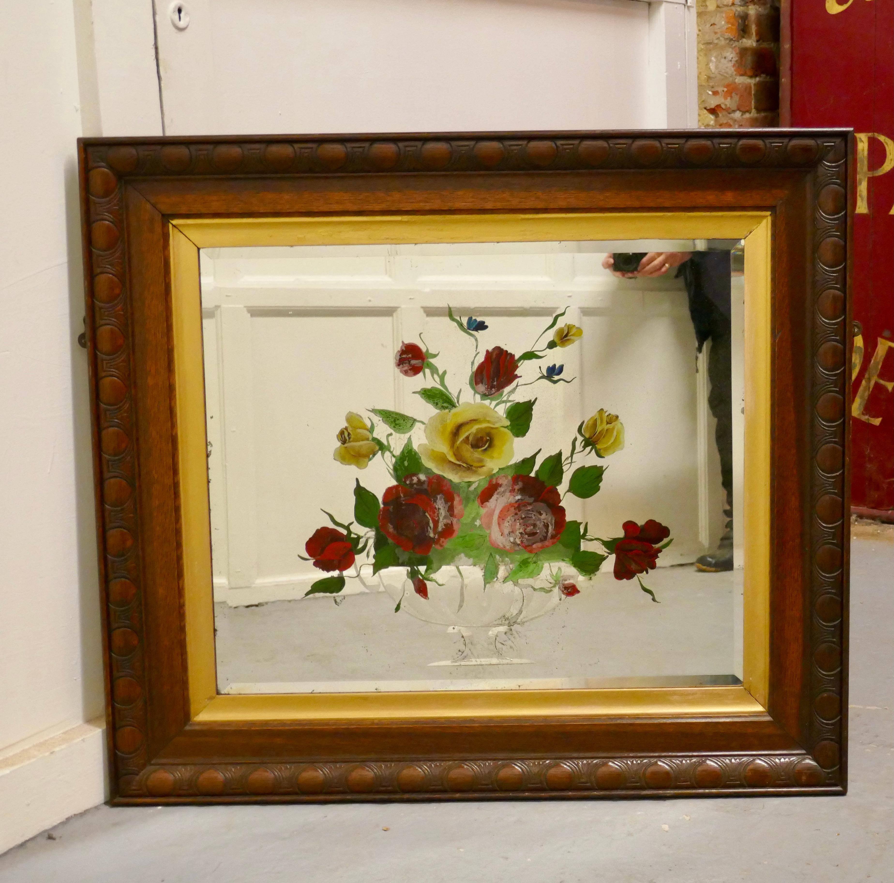 Victorian reverse painted mirror, decorated with roses

The Bevelled mirror is painted from the reverse side with large colourful bold floral decoration set in an urn, it is set on a Carved Oak frame with a gold mount
The mirror is in good sound