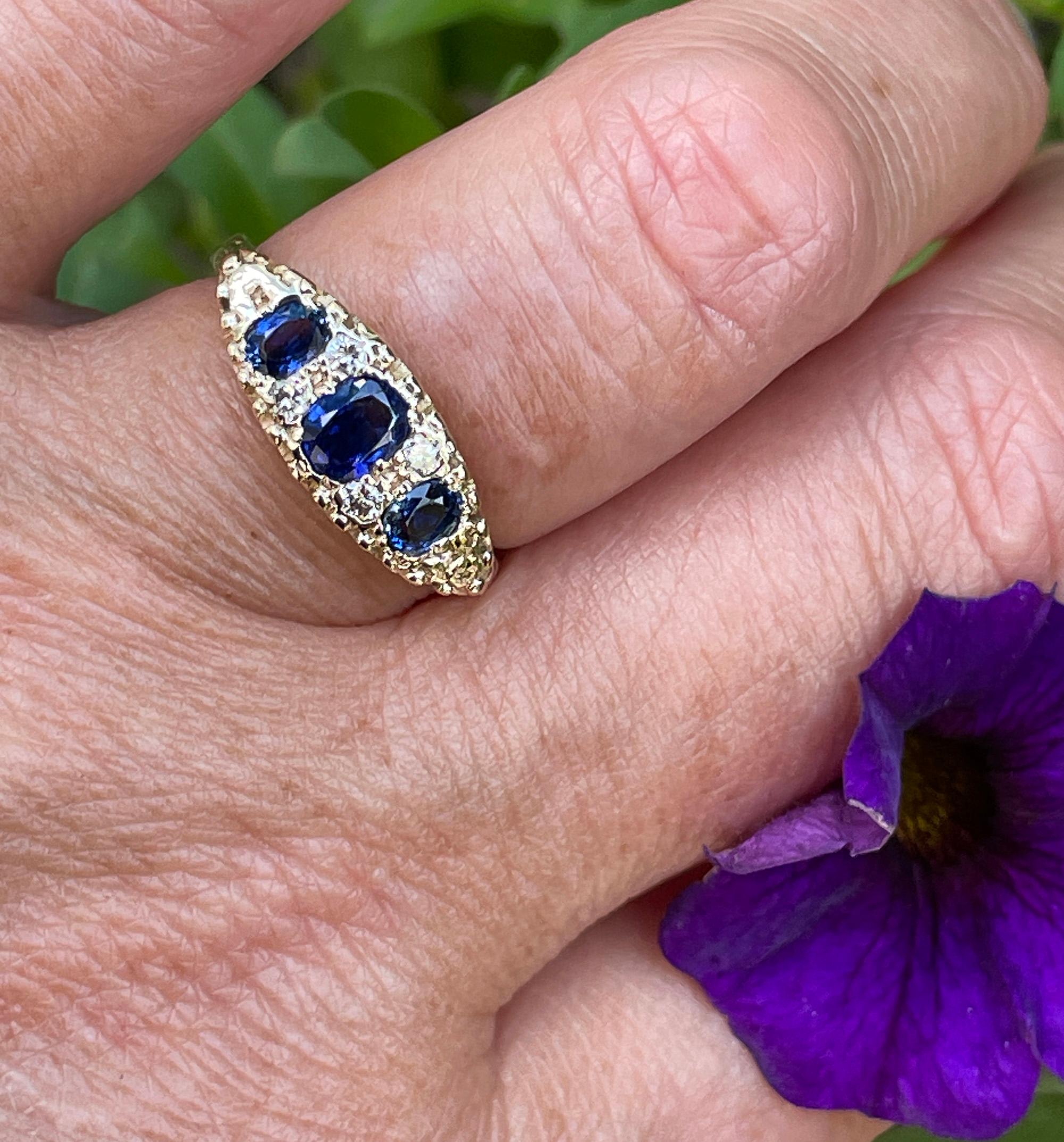 A Beautiful English Vintage Revived VICTORIAN Trilogy 16k Yellow Gold Ring with Blue Sapphires & Diamonds.
A trio of bright deep blue Oval-cut sapphires is accented in dramatic contrast with pairs of bright white and sparkling round diamonds, in