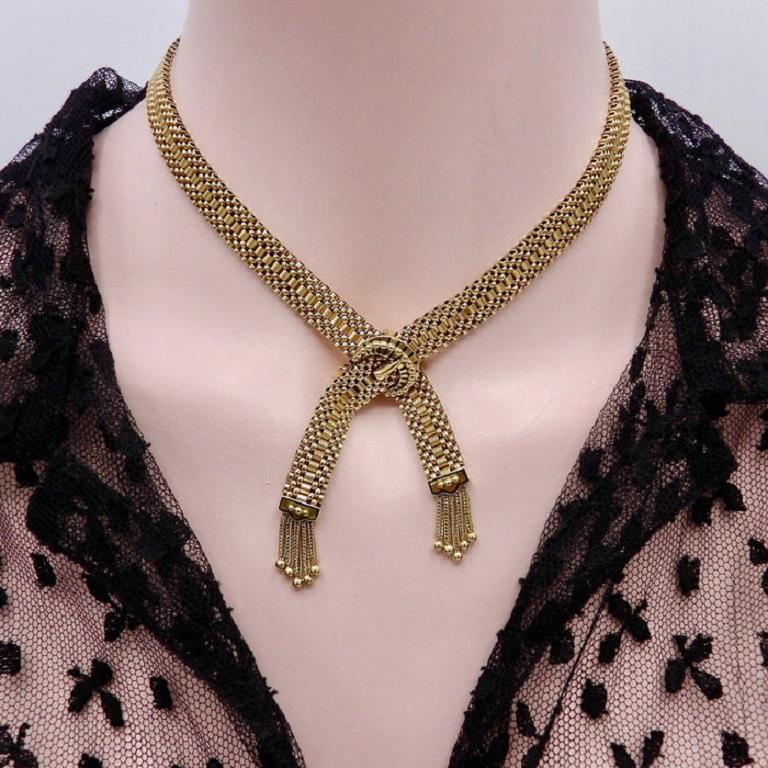 14K Woven Gold Necklace with Buckle Clasp and Tassels

This beautiful woven gold necklace features a crossover adjustable clasp in the shape of a buckle. It is a Victorian revival piece that dates to the 1950's. It has the same attention to detail
