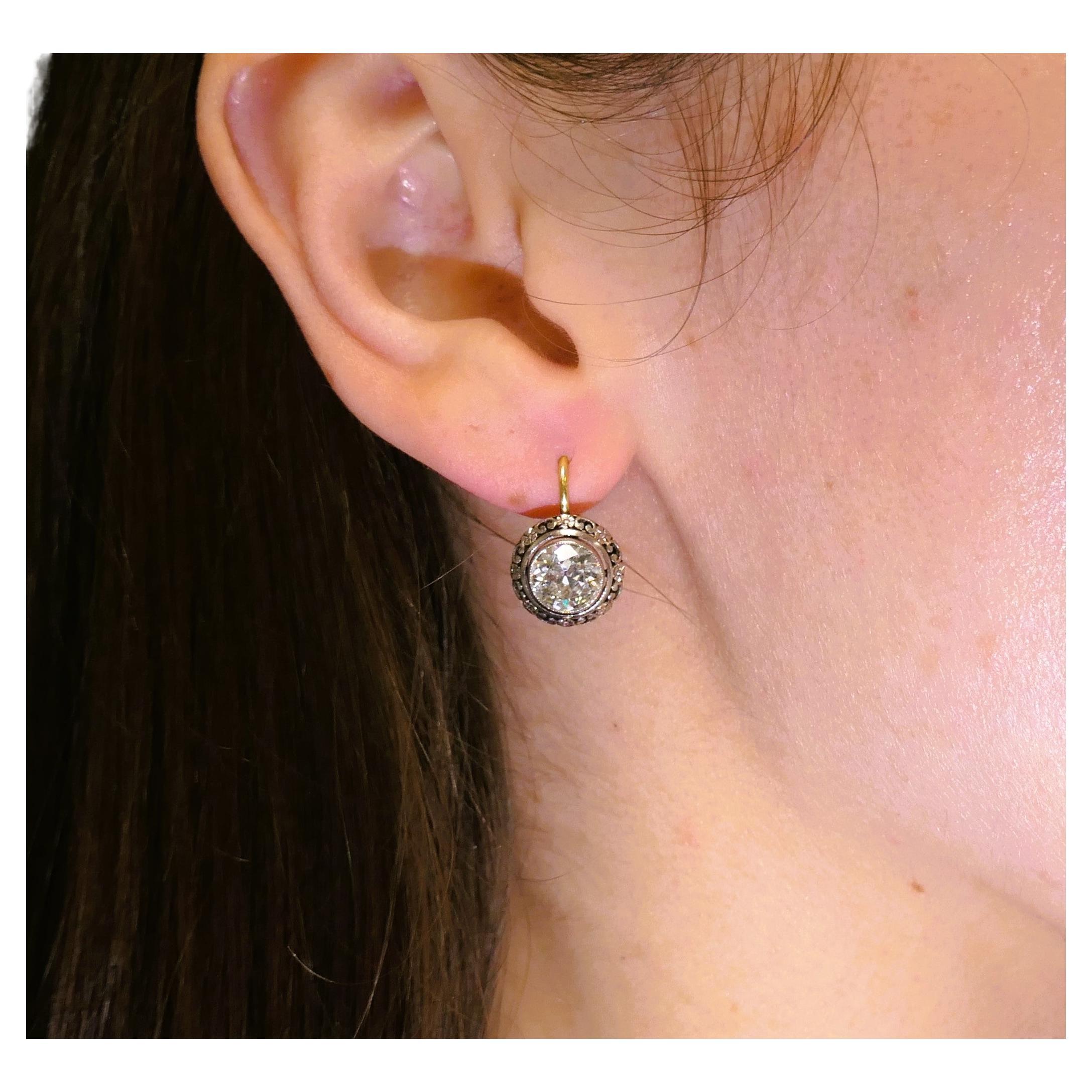 A pair of the Old European cut diamond earrings in Victorian style, made of 18 karat white and yellow gold.
The earrings are circa 1960s and have a classic Victorian look with a contemporary touch. Bezel set diamonds are framed by a white gold