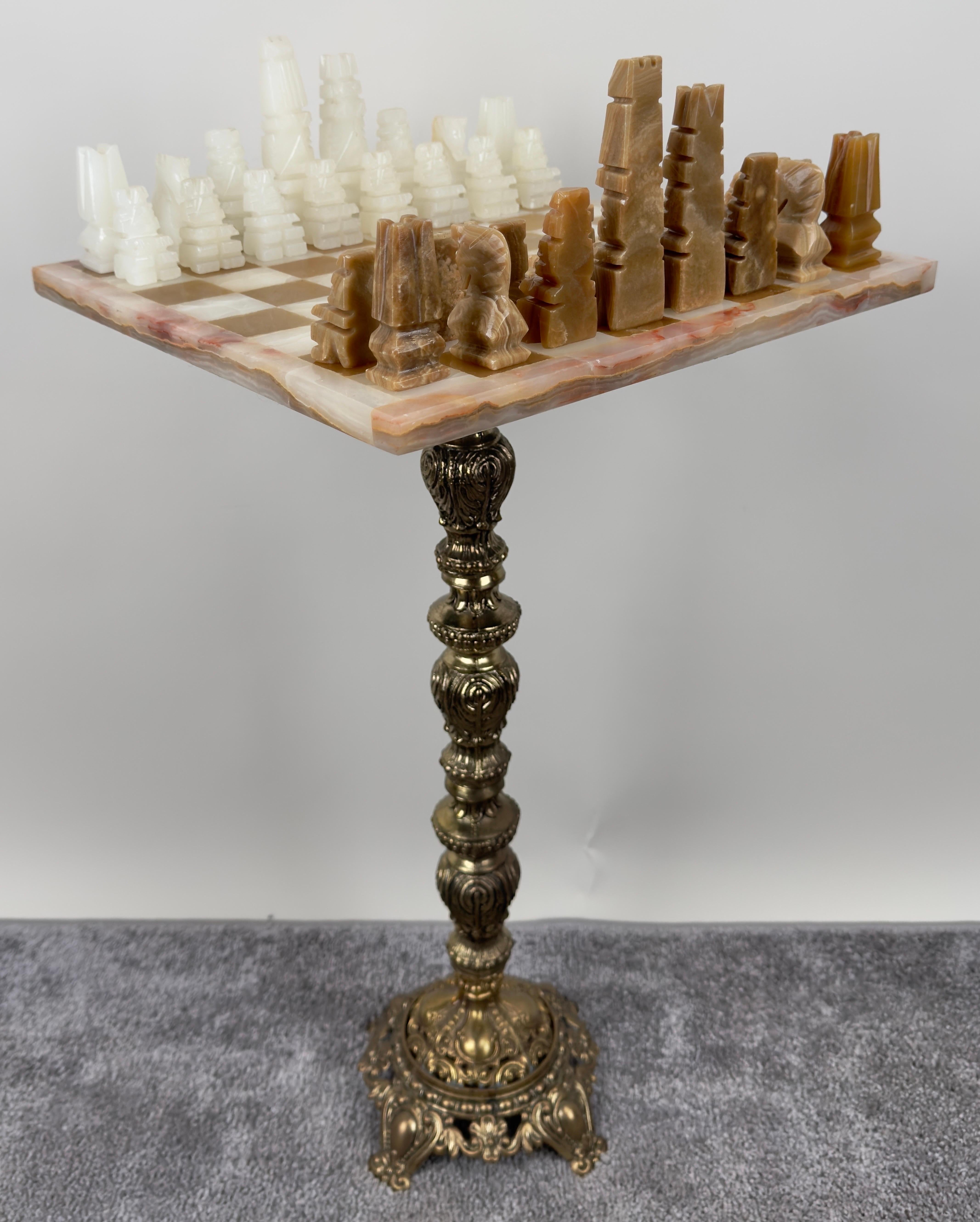 This Victorian Revival set of chess table pieces exudes intricate craftsmanship, combining luxurious materials and regal design. The chessboard features a finely polished marble top, with a subtle blend of creamy beige and pink hues, providing a