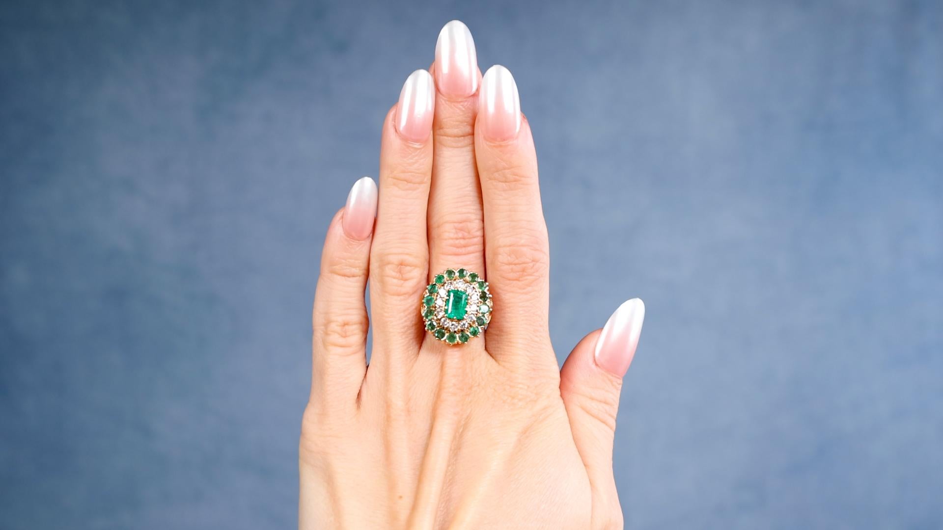 One Victorian Revival Emerald Diamond 14k Yellow Gold Cluster Ring. Featuring one octagonal step cut emerald weighing approximately 1.00 carat. Accented by 12 round brilliant cut diamonds with a total weight of approximately 0.80 carat, graded F-G