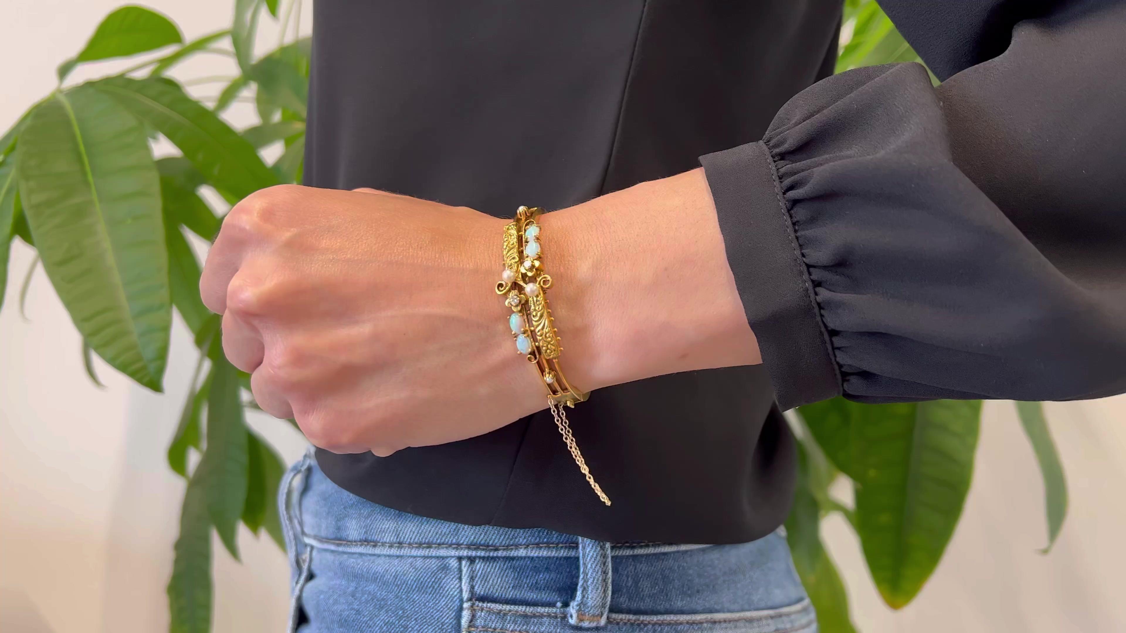 Eine viktorianische Revival Opal, Diamant und Perle 14k Gelbgold Scharnier Manschette Armband. Ausgestattet mit vier Perlen. Akzentuiert durch vier Cabochon-Opale mit einem Gesamtgewicht von ca. 1,10 Karat und zwei runde Diamanten im Brillantschliff