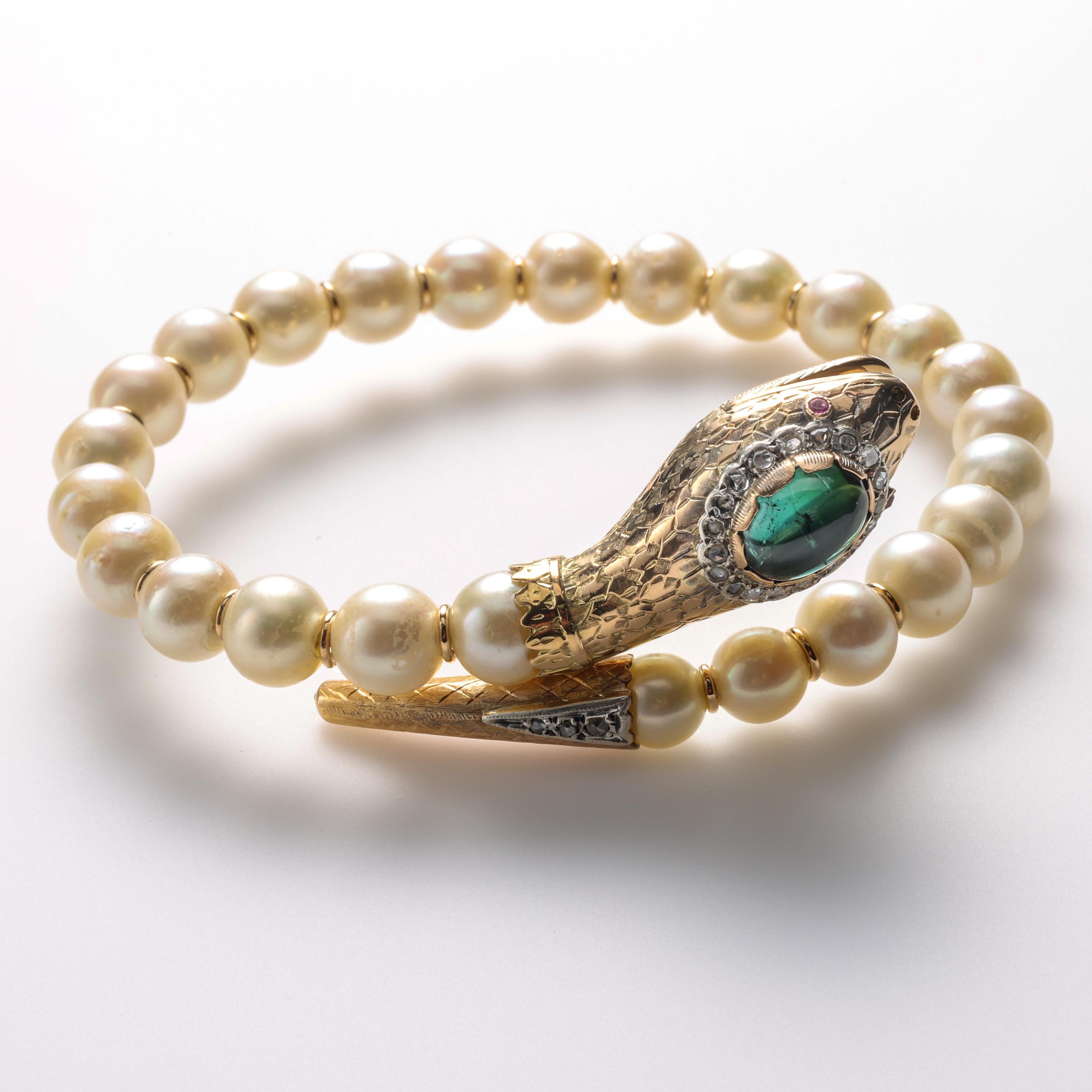 This ravishing and utterly unique serpent bracelet was created near the 1940s in the Victorian style. Twenty-five saltwater pearls strung on 15K (at least) gold are capped on either end with the head and tail of an endearingly charming serpent. The