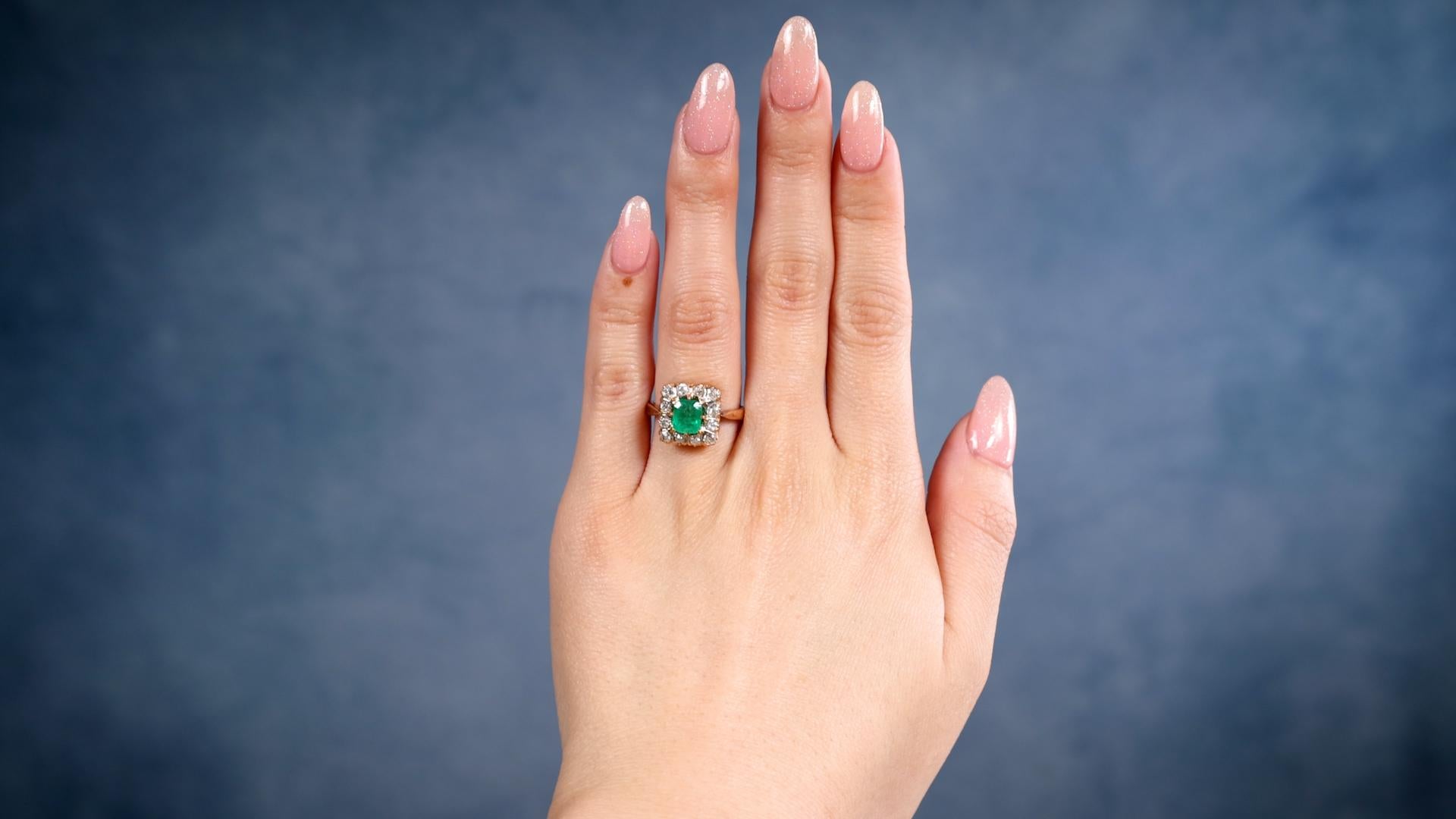 Ein viktorianisches Revival Quadrat Smaragd Diamant 18k Rose Gold Cluster Ring. Mit einem rechteckigen Smaragd im Stufenschliff mit einem Gewicht von etwa 0.60 Karat. Akzentuiert durch 12 Diamanten im Übergangsschliff und im alten europäischen