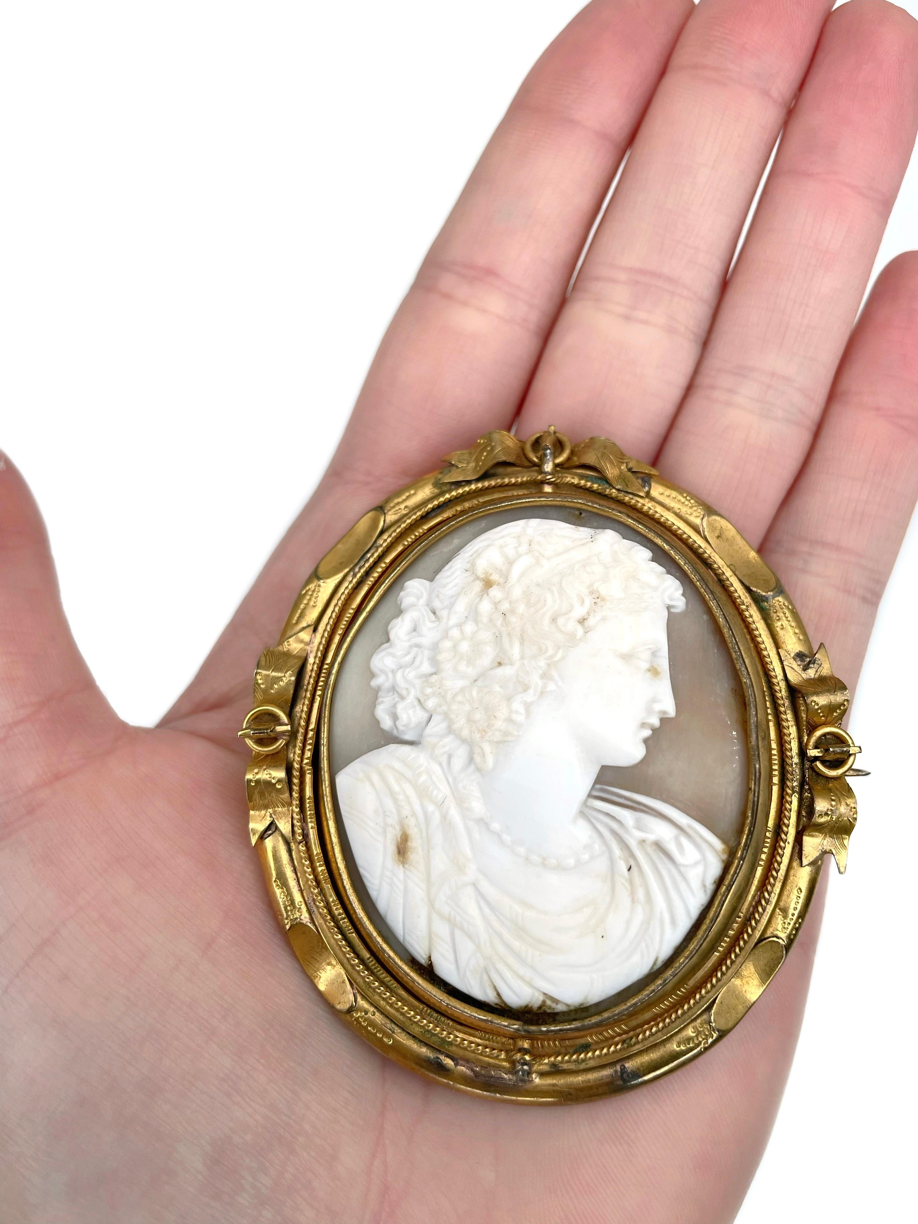This is a Victorian large oval pin brooch crafted in pinchbeck. Circa 1860. 

The piece features a shell cameo depicting a lady facing right. The center part moves on a swivel. On the reverse there is a place for a photo. 

Has a bail. Can be worn