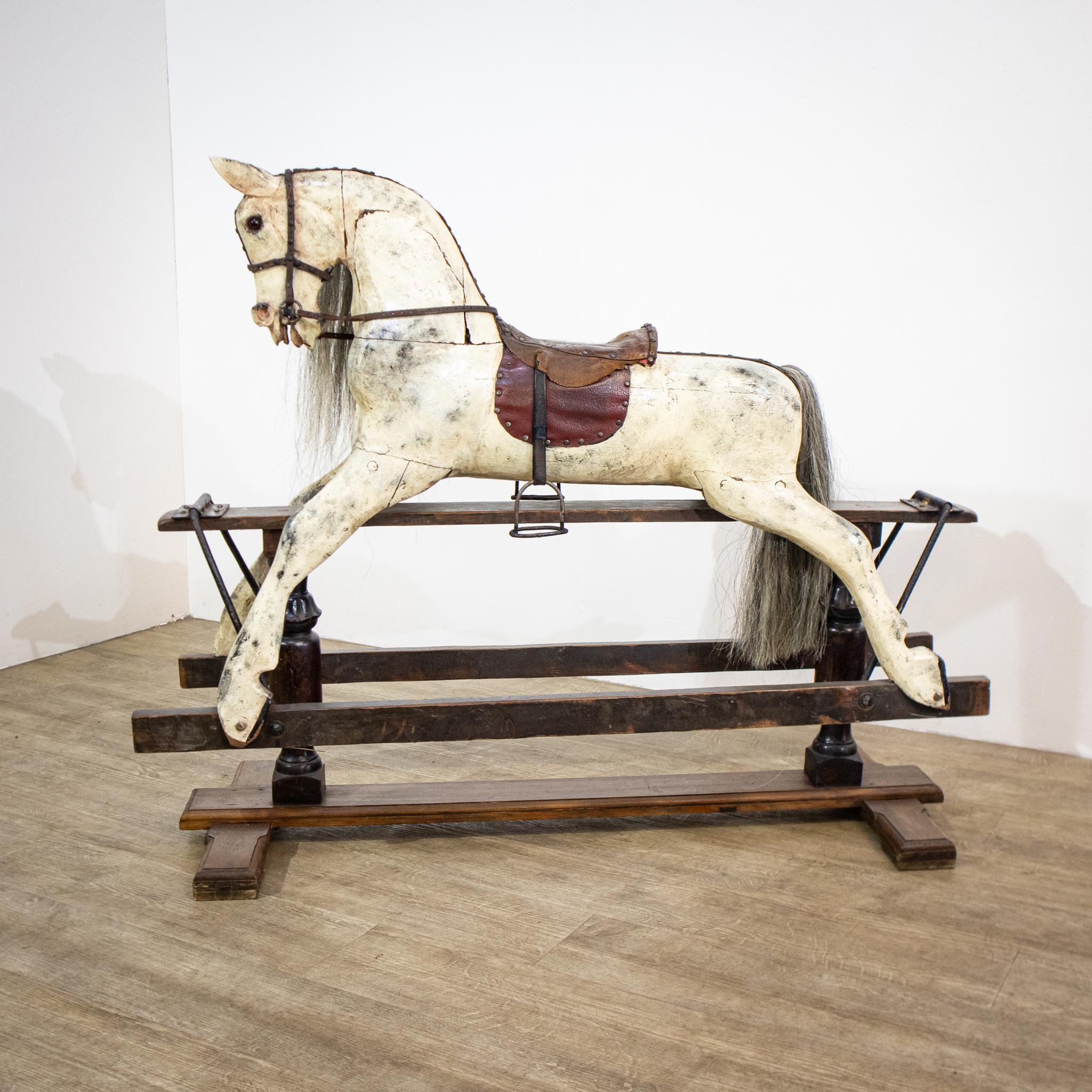 A Victorian rocking horse which will delight any small child and continues to function for its original purpose, this is a dappled white with a leather saddle, bridle and reins, horsehair tail and mane, glass eyes and iron stirrups. The sturdy base