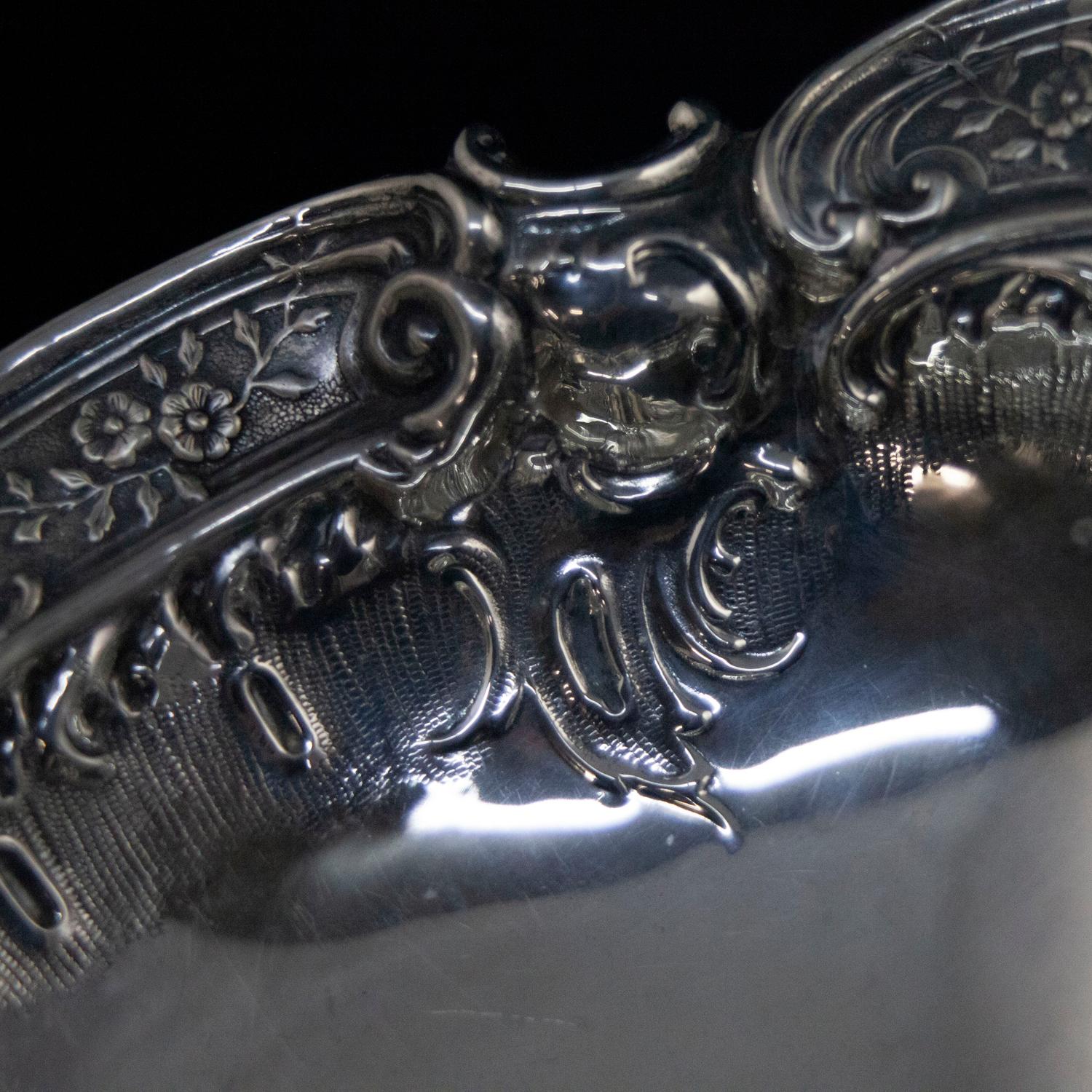 A Victorian Rococo .800 silver center serving bowl features oval form with high relief foliate and scroll decoration and two scroll form handles, raised on four foliate form feet, circa 1880

Measures: 4.5