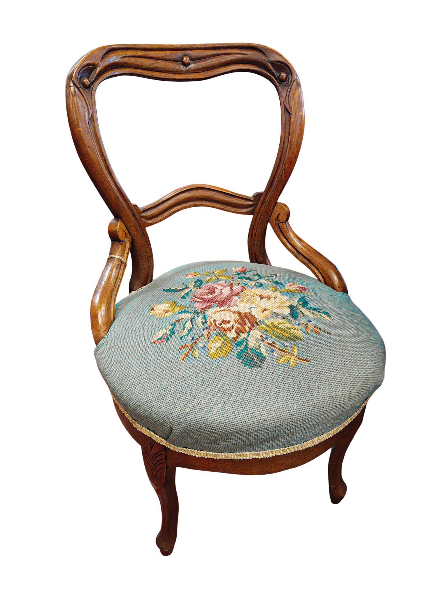 Cette élégante chaise incarne le style néo-rococo victorien en vogue des années 1840 aux années 1870. Fabriquée en bois dur foncé - probablement du noyer - elle présente la forme caractéristique du dos ballon avec un rail arrondi et sculpté et des