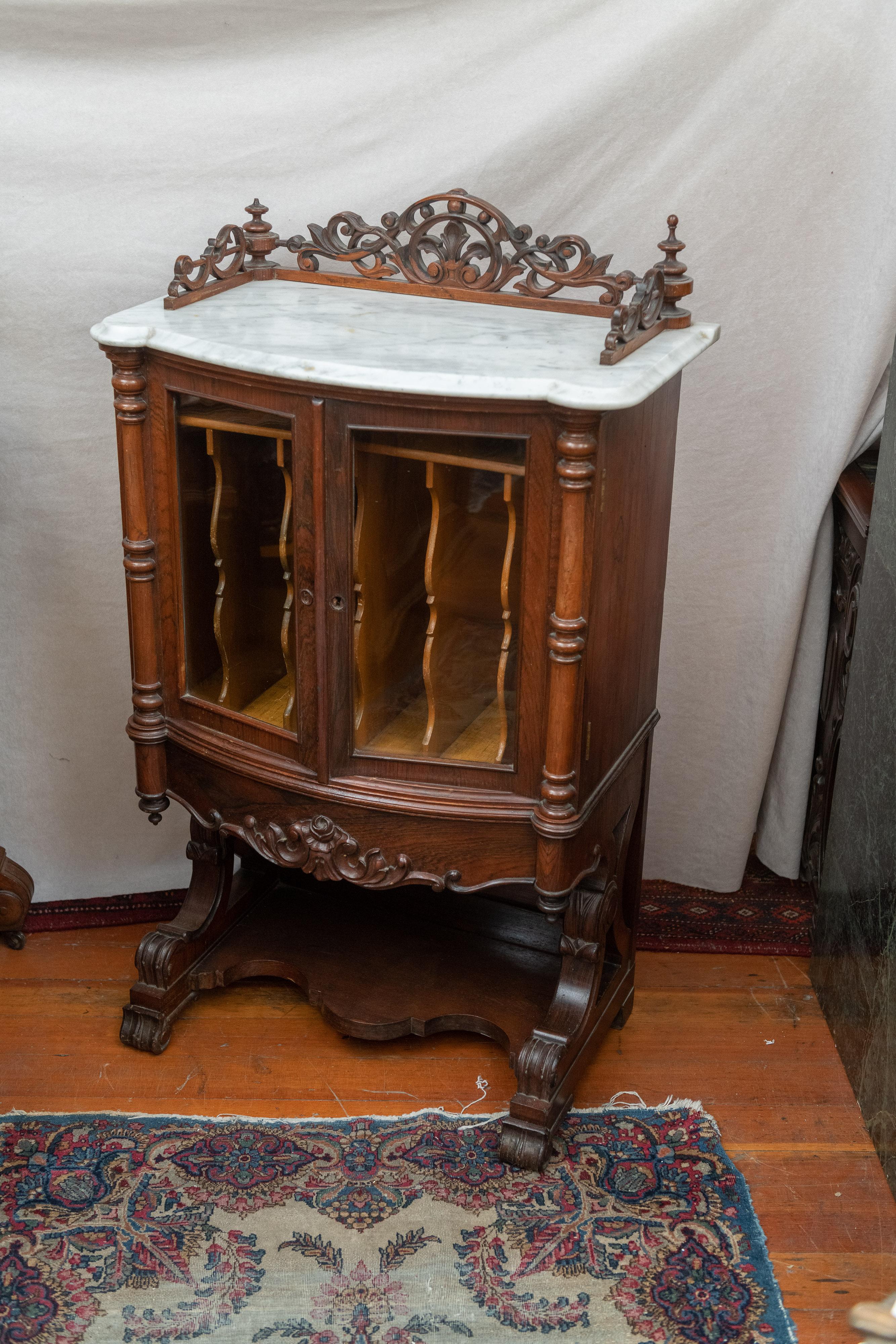 This is certainly one of the nicer music cabinets ever made. Handsome rosewood and white marble make this cabinet a fine example. This is American Rococo design and therefore made in the 1860's. Rosewood is one of the most beautiful and sought after