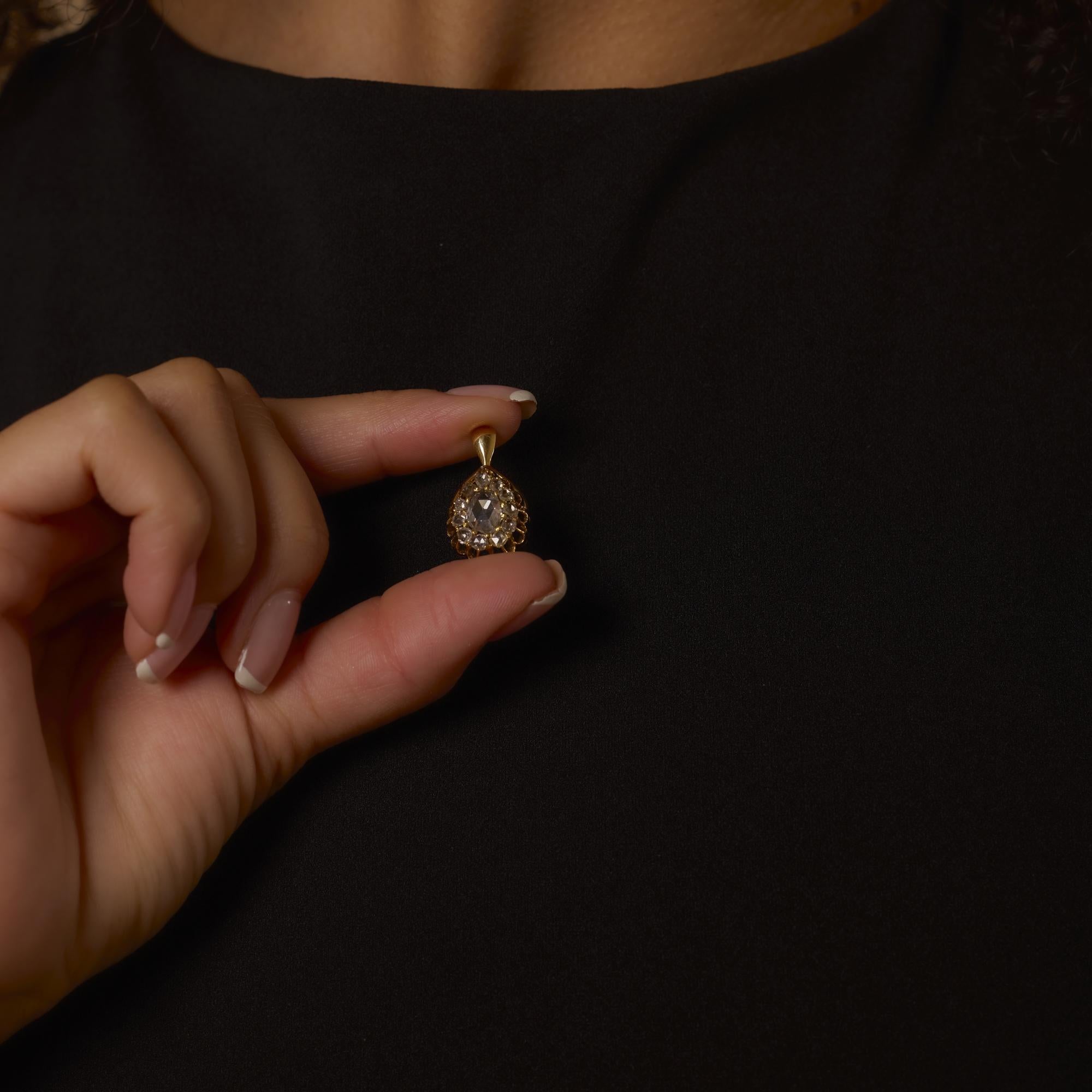 Este encantador colgante de la época victoriana exhibe un luminoso diamante ovalado talla rosa de 0,50 quilates rodeado de once acentos talla rosa en rico esmalte y oro amarillo de 18 quilates.