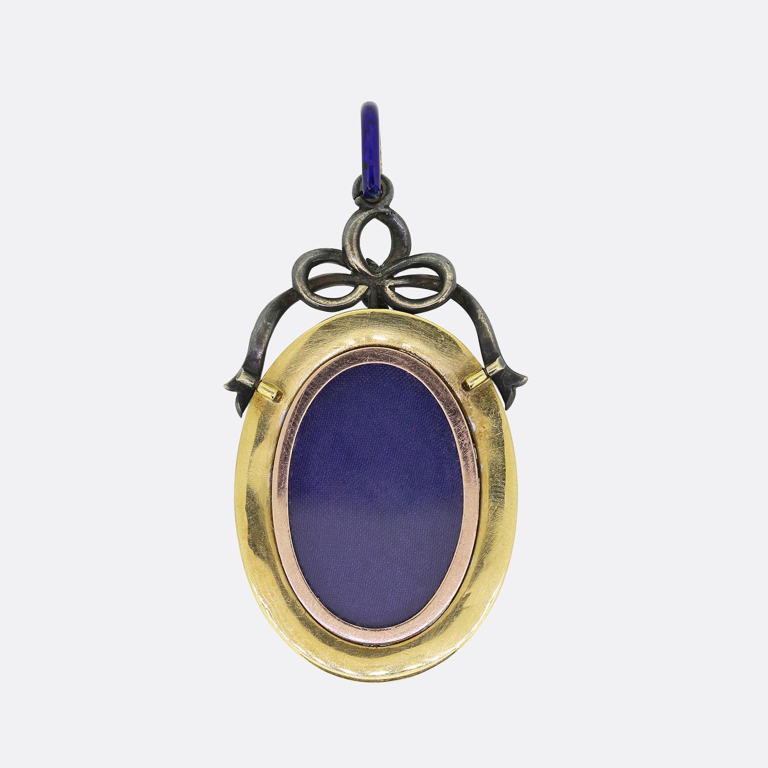 Aquí tenemos un encantador medallón antiguo de la época victoriana. Una ventana de cristal ovalada está enmarcada por un atrevido esmalte eléctrico y azul marino con motivos engastados de diamantes en oro amarillo como compañía. Un lazo de plata