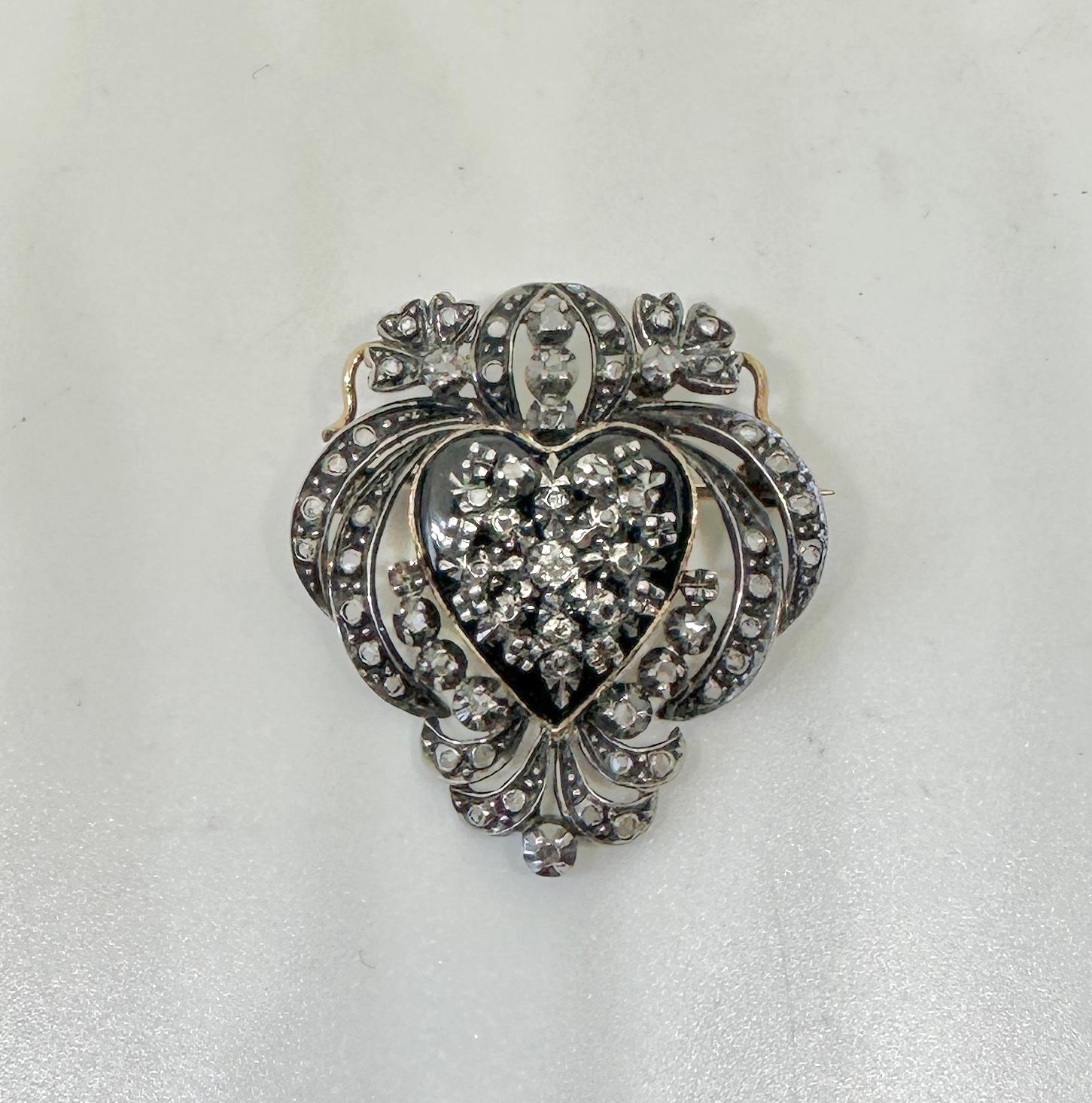 Indulge in a spectacular Antique Victorian Rose Cut Diamond and Black Onyx Heart Pendant Necklace or Brooch in Silver atop 18 Karat Yellow Gold.  The romantic and elegant Victorian jewel has a Black Onyx heart in the center.  The silver and gold