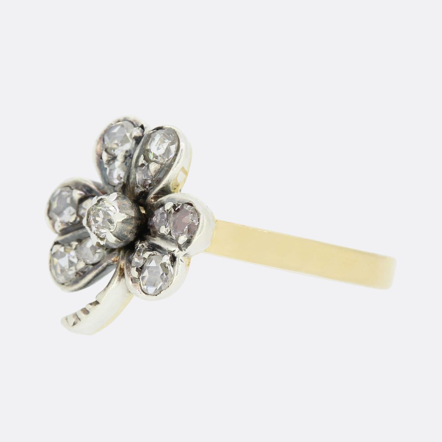 This is a beautiful, 18ct yellow gold diamond clover ring. The ring features a central old cut diamond and surrounded by twelve rose cut diamonds in a clover motif crafted in silver with an 18ct yellow gold band.

The ring started life as a