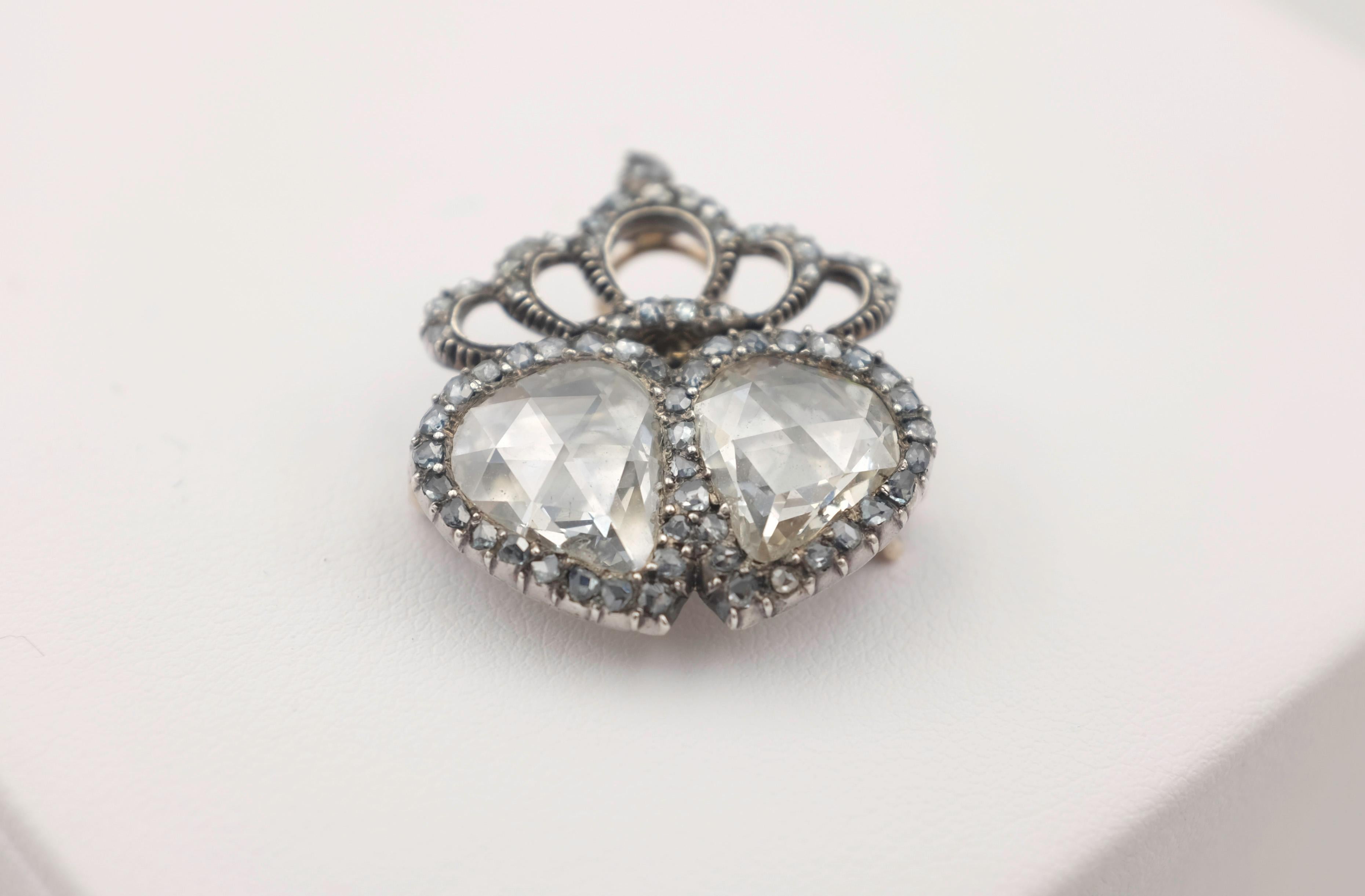 From THE PERSONAL COLLECTION OF FRED LEIGHTON.  Designed as a pair of hearts beneath a crown motif, composed of two foil backed pear-shaped rose-cut diamonds, framed and topped with rose-cut diamonds, with French import and Dutch assay marks; circa