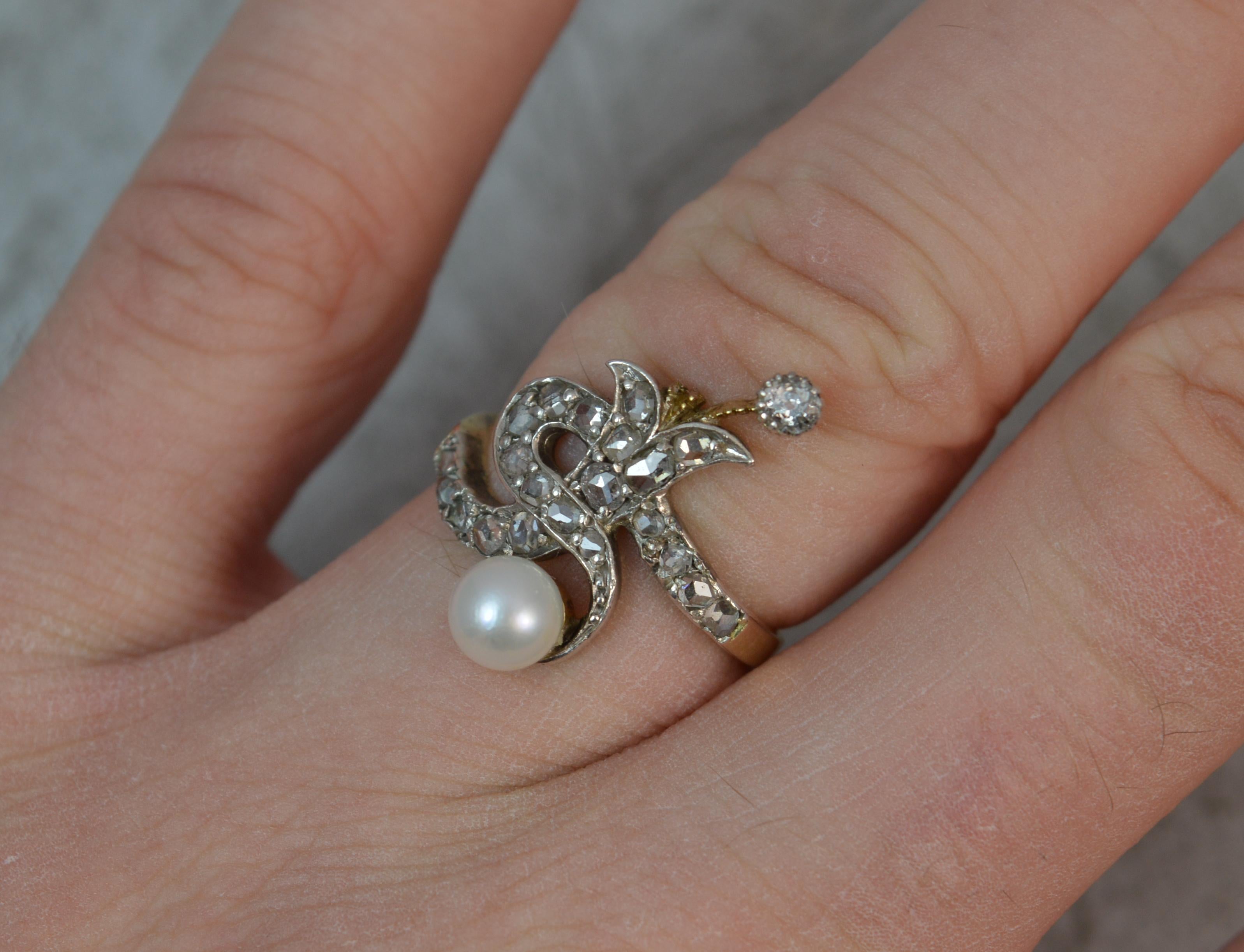 A stunning late Victorian period cluster ring.
Modelled in 18 carat yellow gold shank and platinum head setting.
Formed with many rose cut diamonds with old cut diamond and pearl top and bottom. Overall cluster resembles a serpent like